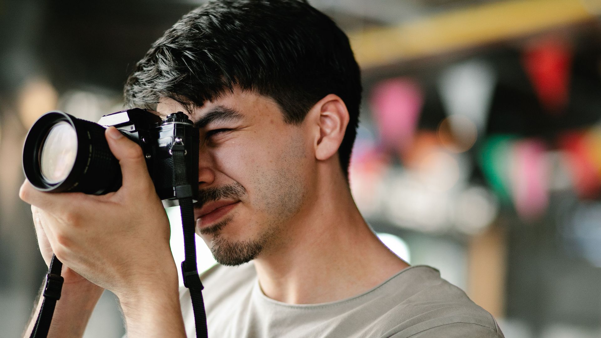 Focused photographer using a DSLR camera, capturing candid moments indoors.