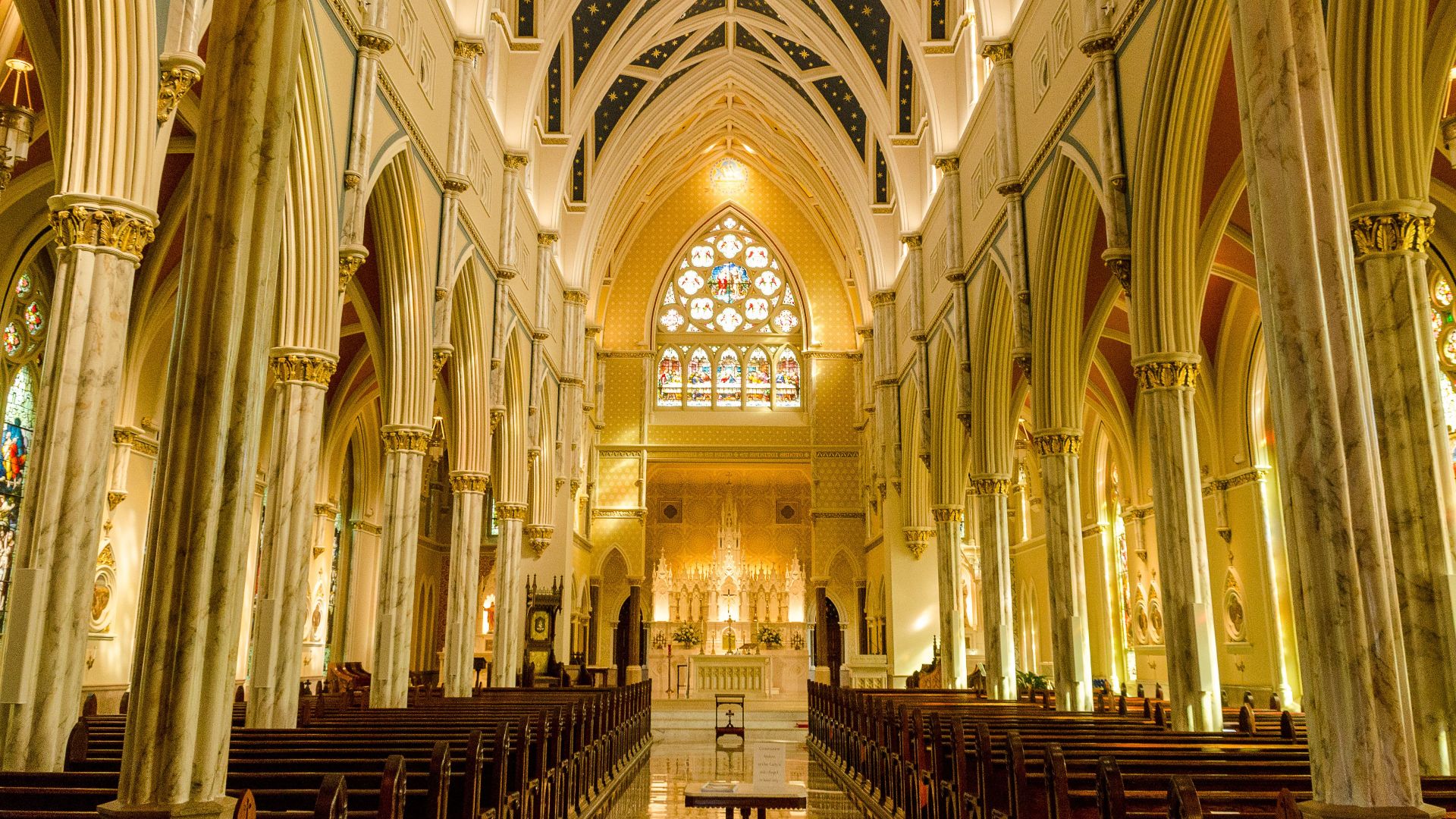 Explore the breathtaking architectural details of a Charleston cathedral with stained glass and towering arches.