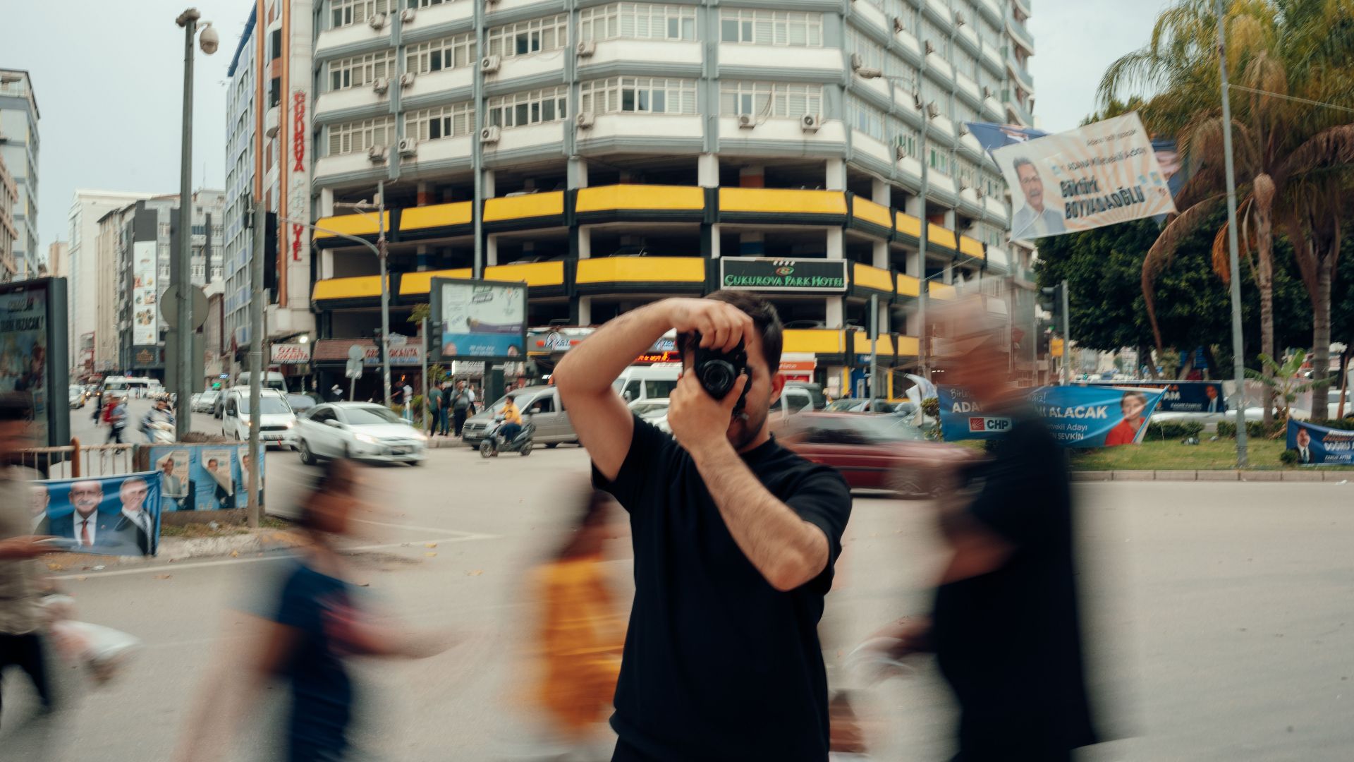 A photographer captures city life as pedestrians blur by on a bustling street.