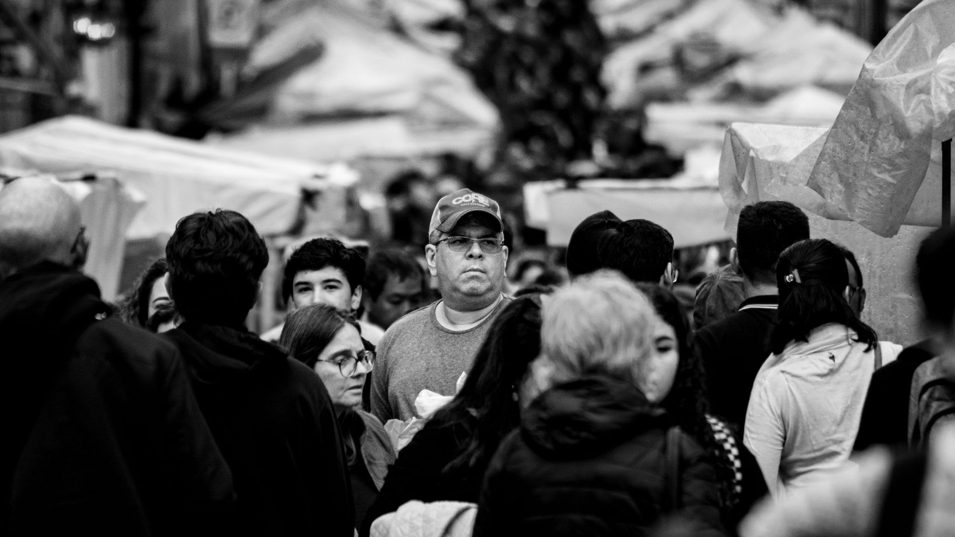 Black and white street scene capturing a bustling market crowd in Buenos Aires, Argentina.
