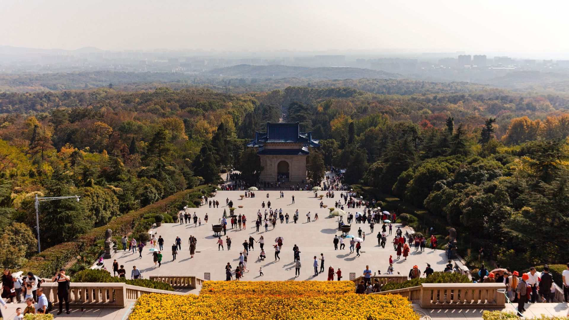 Aerial view of Sun Yat-sen Mausoleum with crowds and lush forest in Nanjing, China.