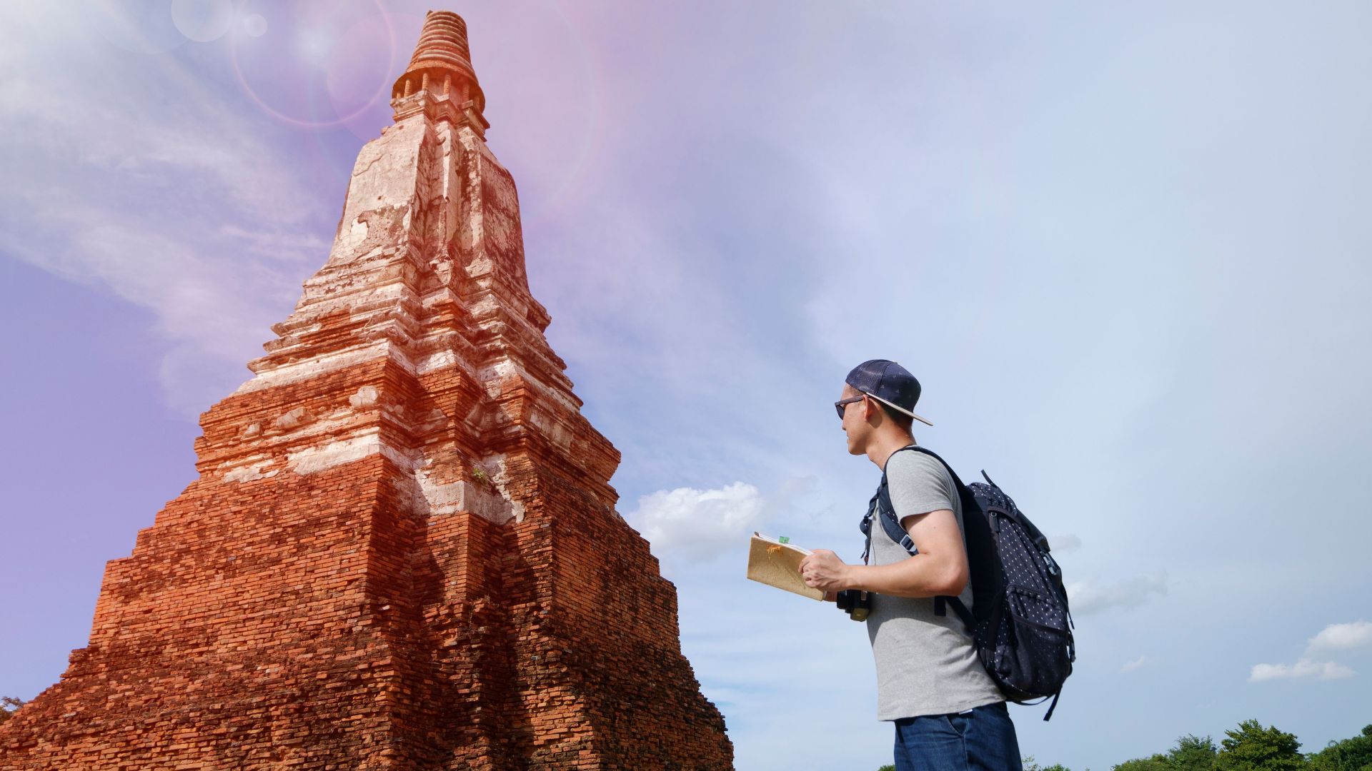 A young traveler with a backpack examines ancient temple ruins under a clear sky, capturing a serene adventure.