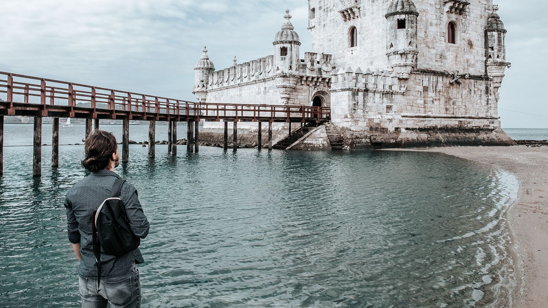 Traveler gazing at iconic Belem Tower in Lisbon, Portugal.