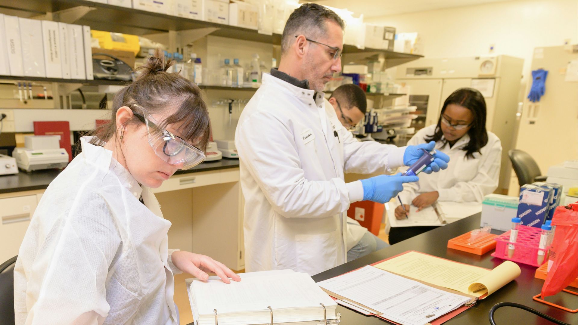 a group of people in lab coats working in a lab
