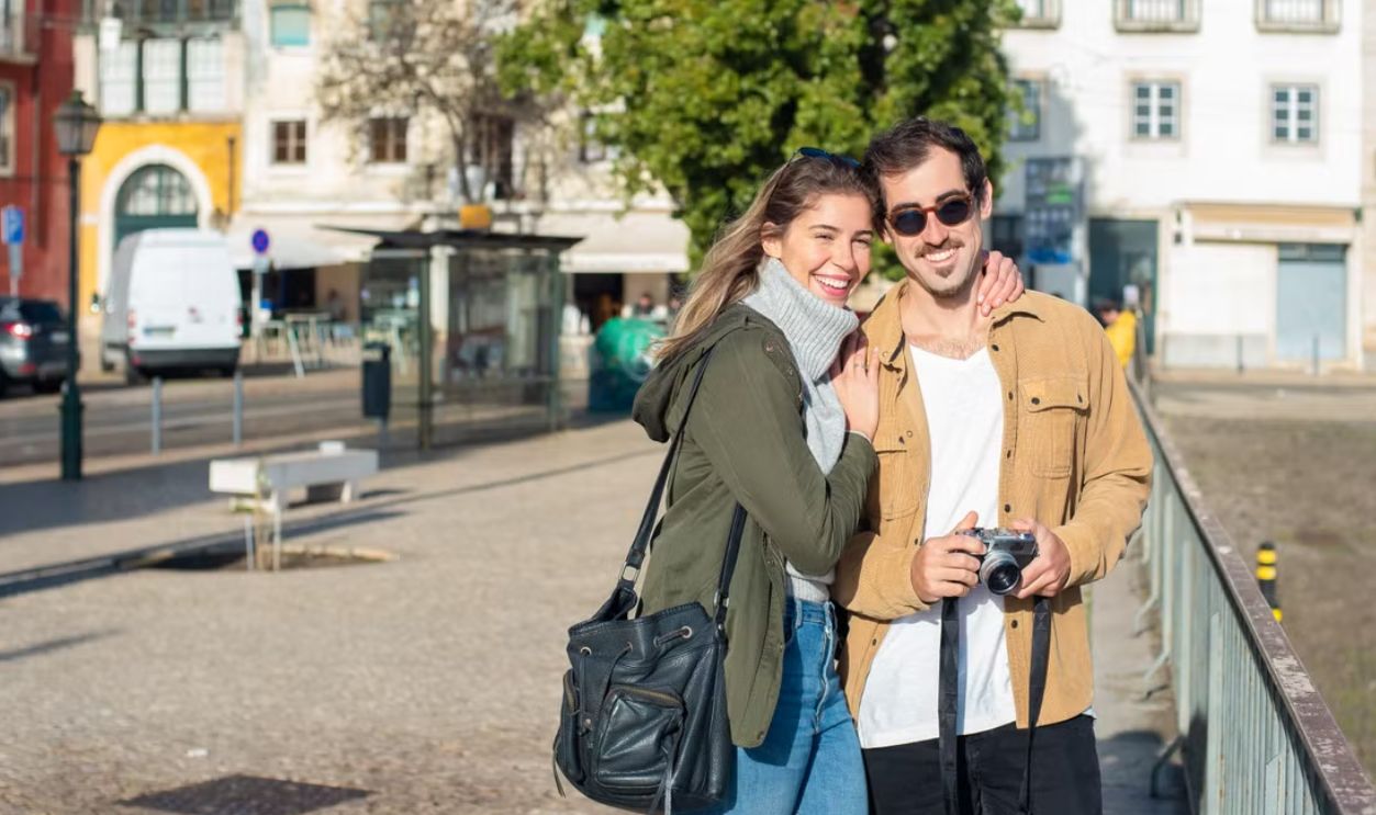 Smiling couple enjoying a day out capturing memories in a picturesque city