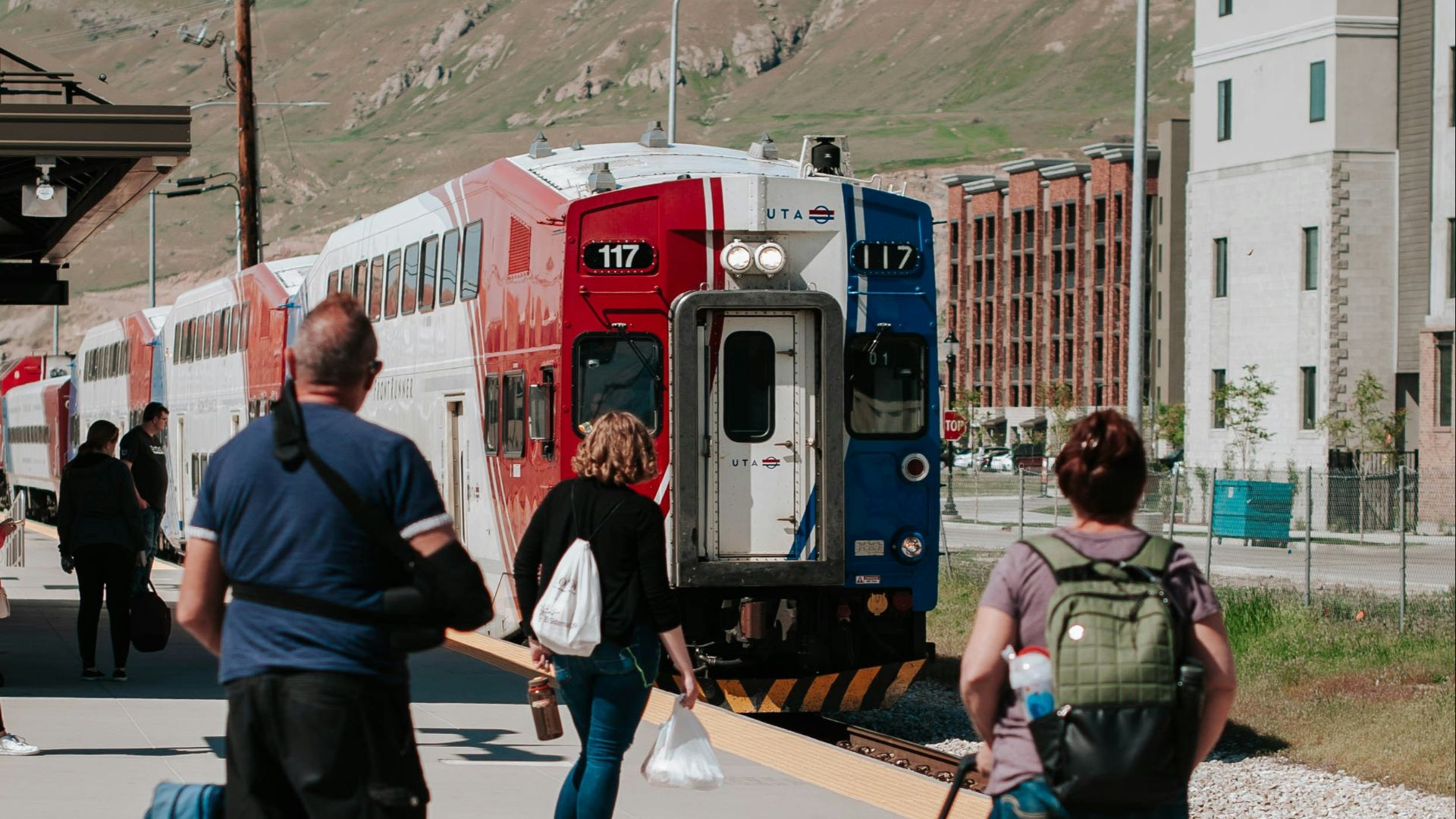 woman in blue denim shorts standing beside red and white bus during daytime