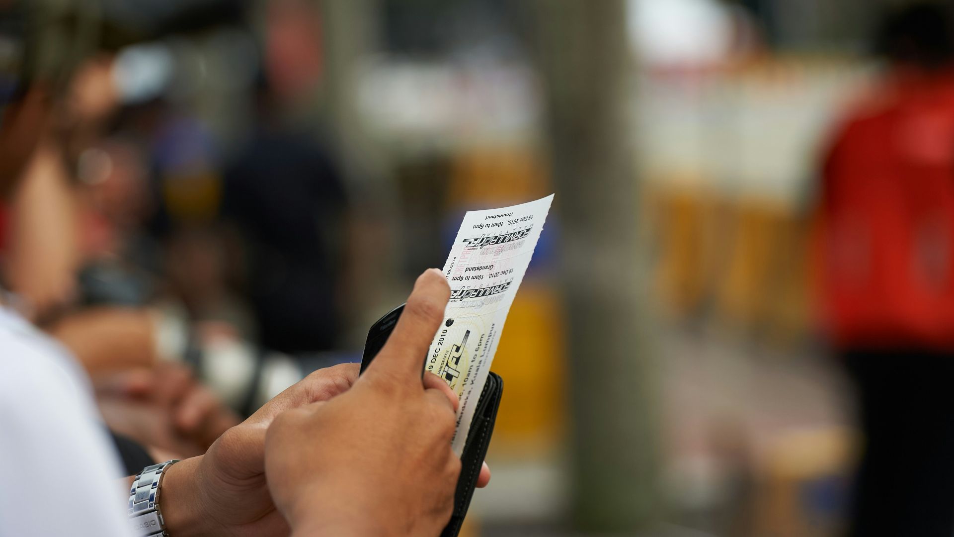 Person holding a lottery ticket with blurred background