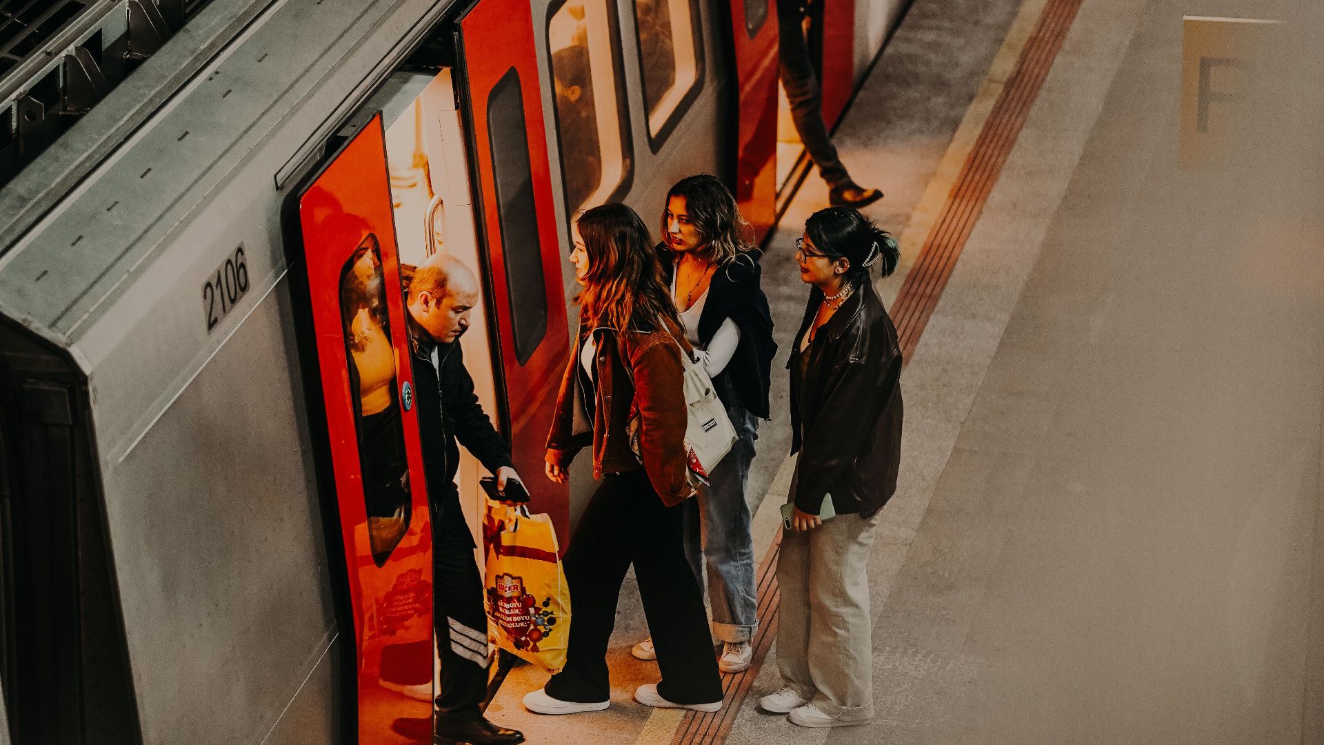 Aerial view of people entering a subway train on a city platform in Ankara, Türkiye.