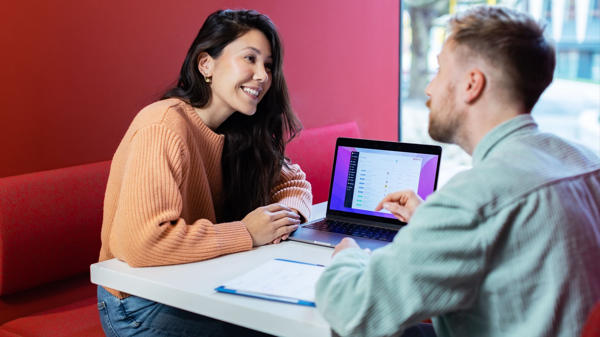 Two colleagues discussing business ideas over a laptop in a New York City cafe.