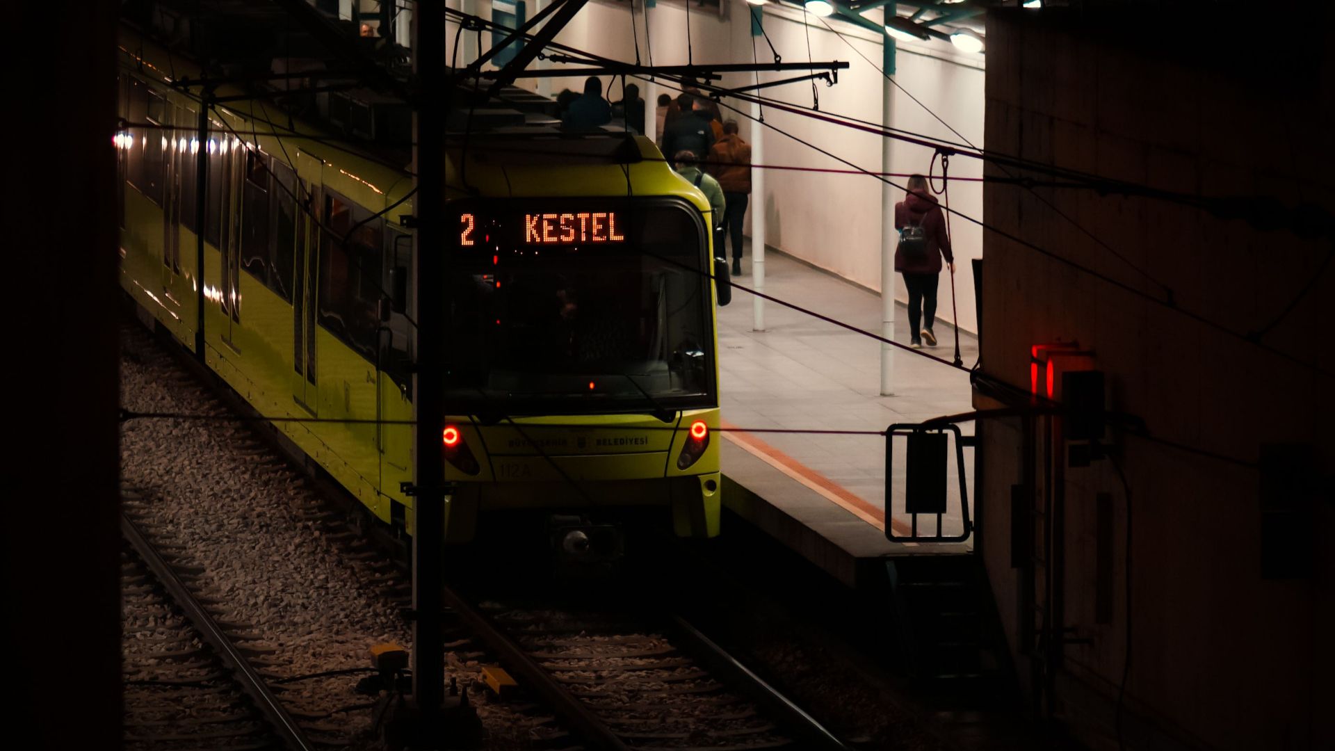 An urban train at a station platform captured at night, showcasing public transportation.