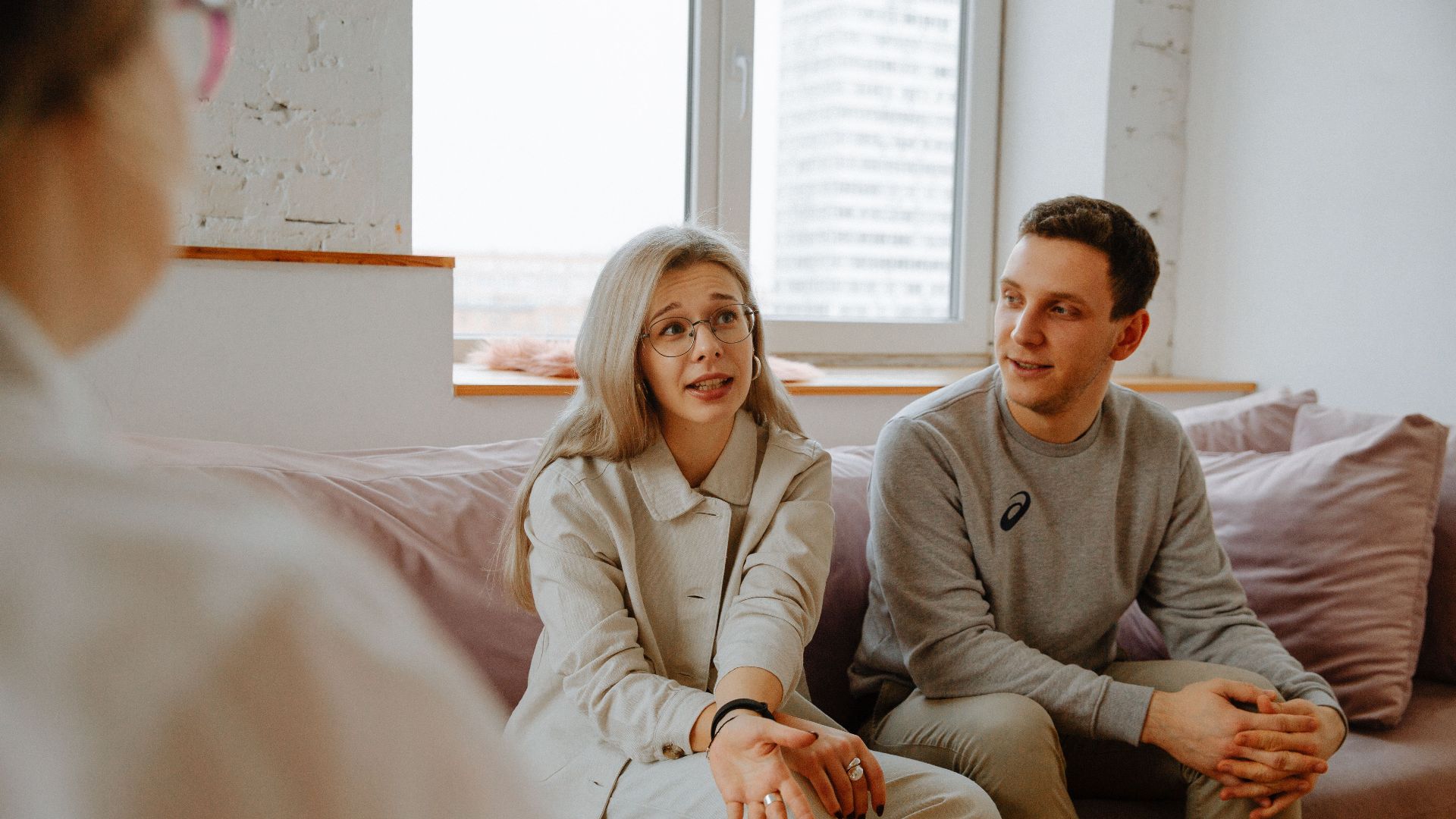 A couple and therapist engaged in a discussion during a therapy session indoors.
