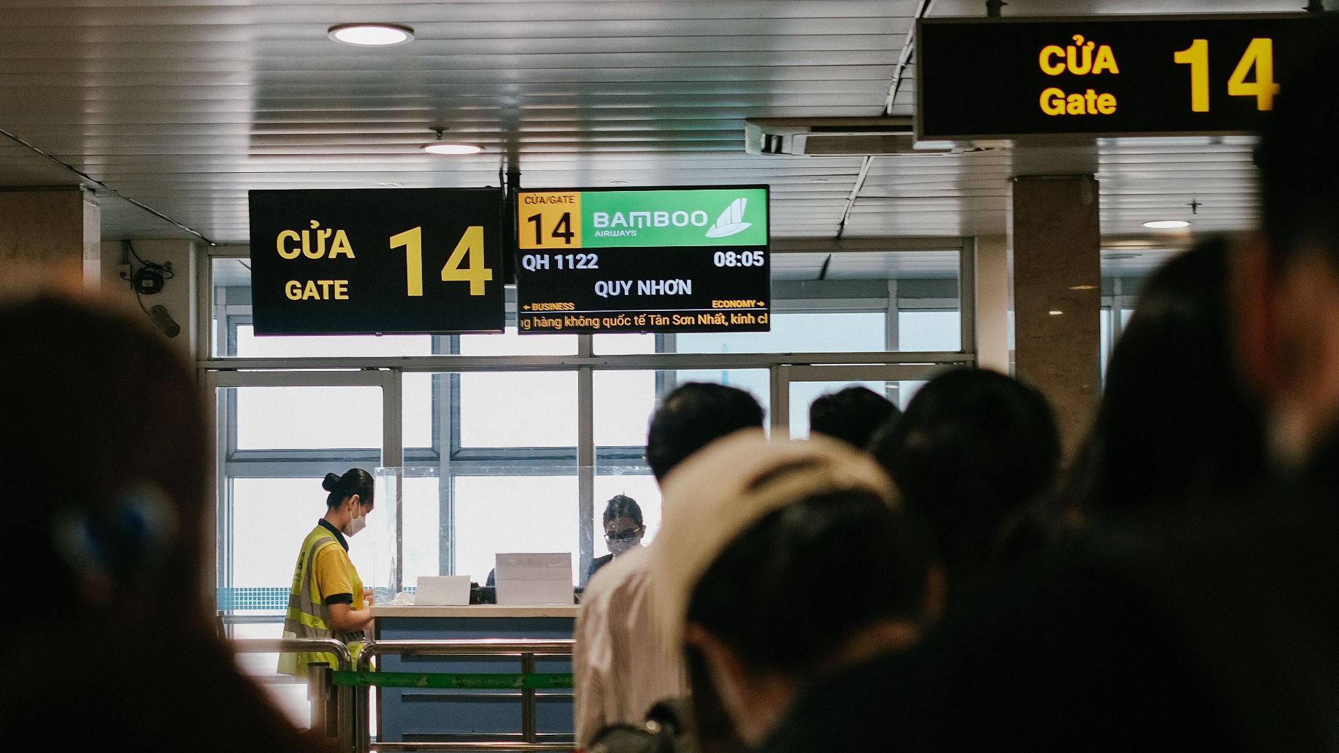 People standing in line at an airport gate, waiting to board a flight.