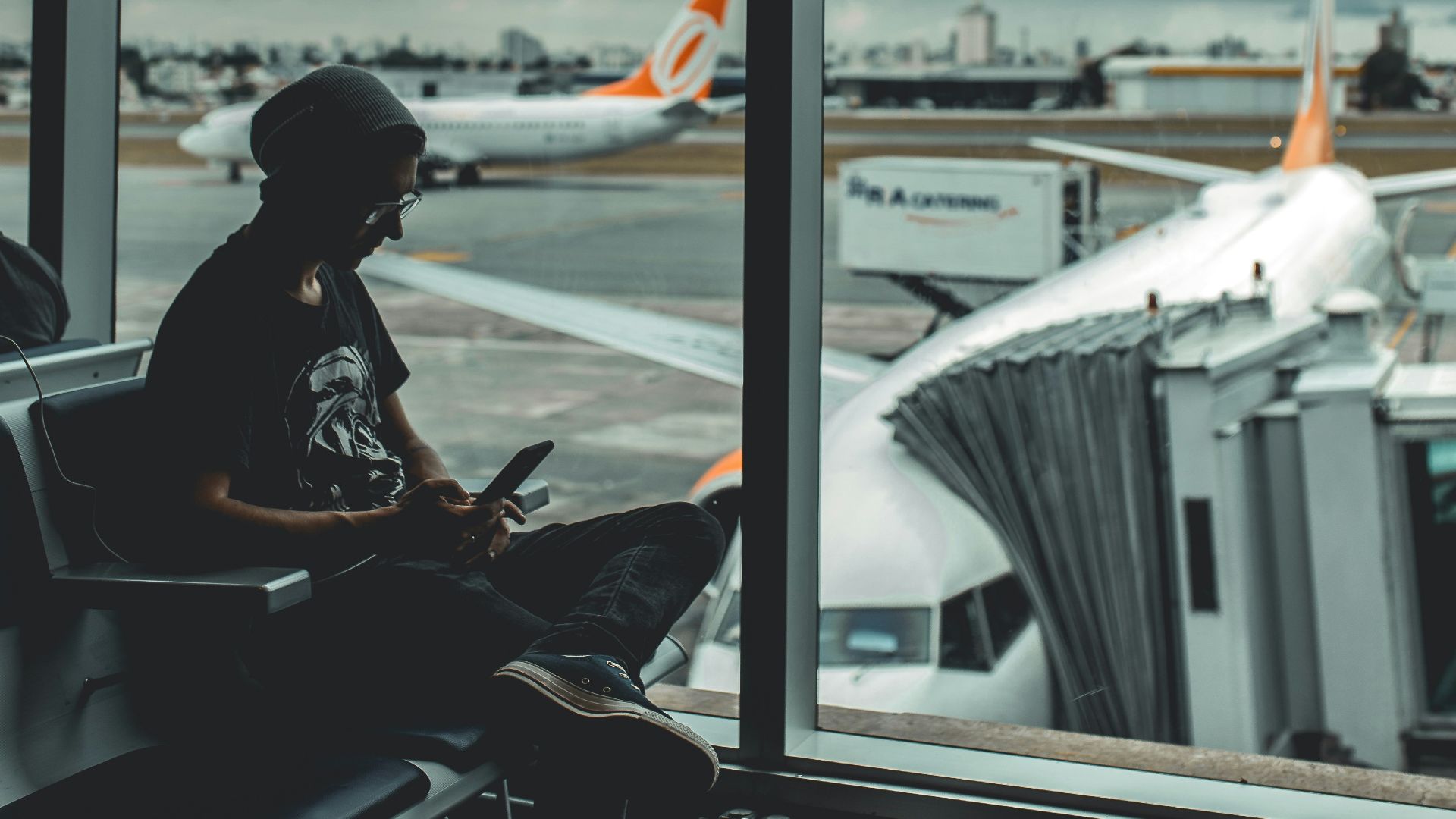 man browsing his phone in airport