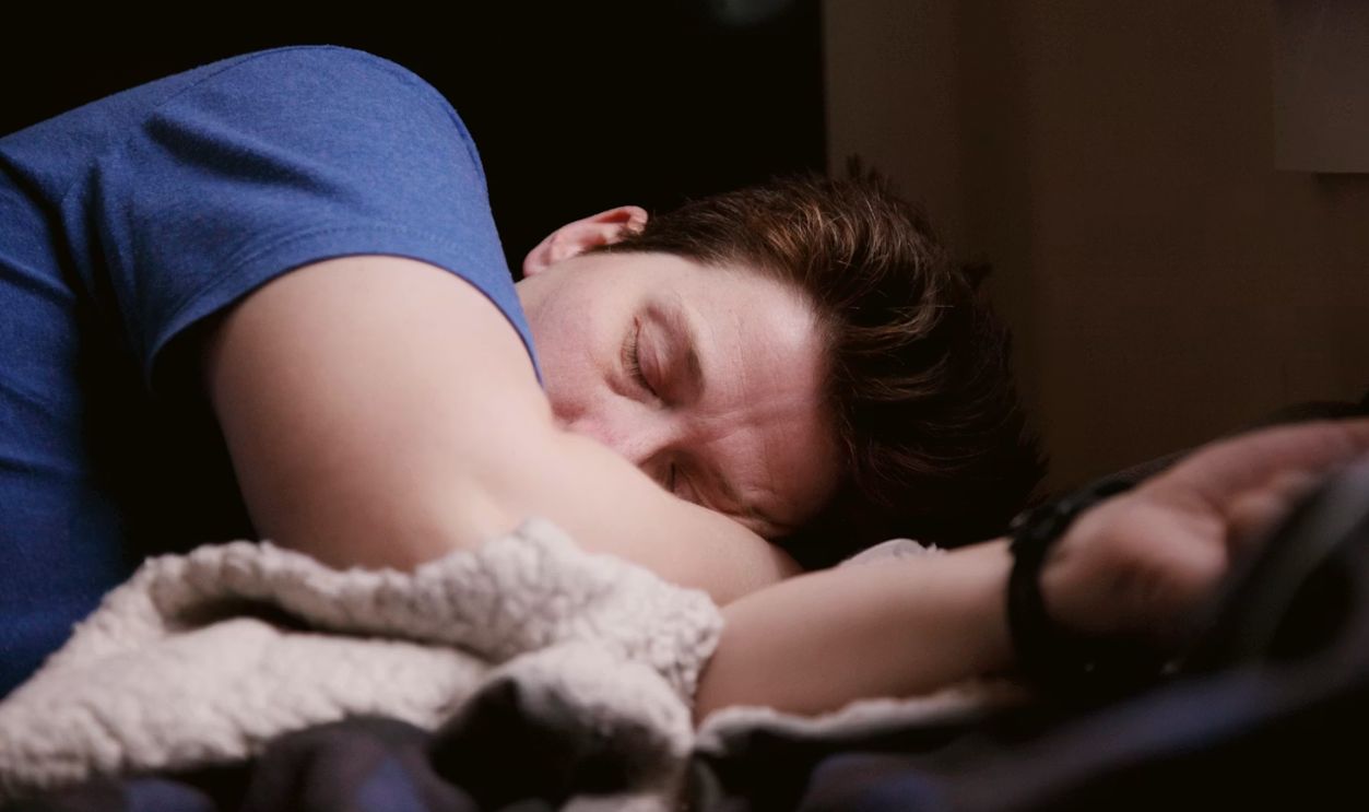 man in blue shirt sleeping