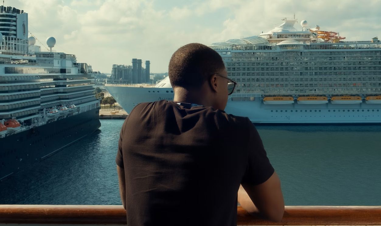 Man looking at cruise ships docked in a harbor