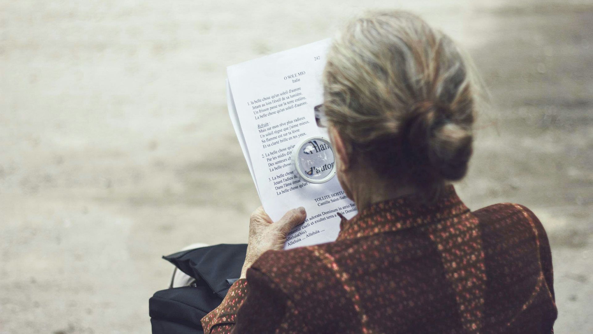 woman in brown top reading paper