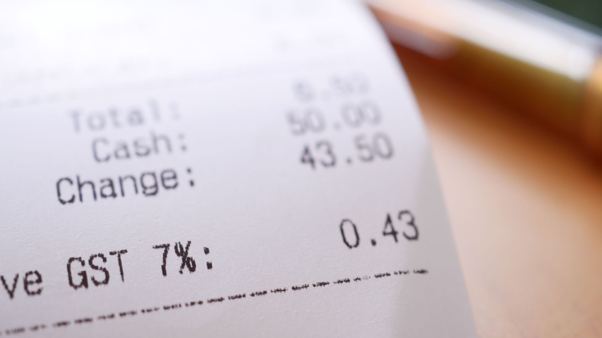 Detailed close-up image of a shopping receipt showing GST and total changes.