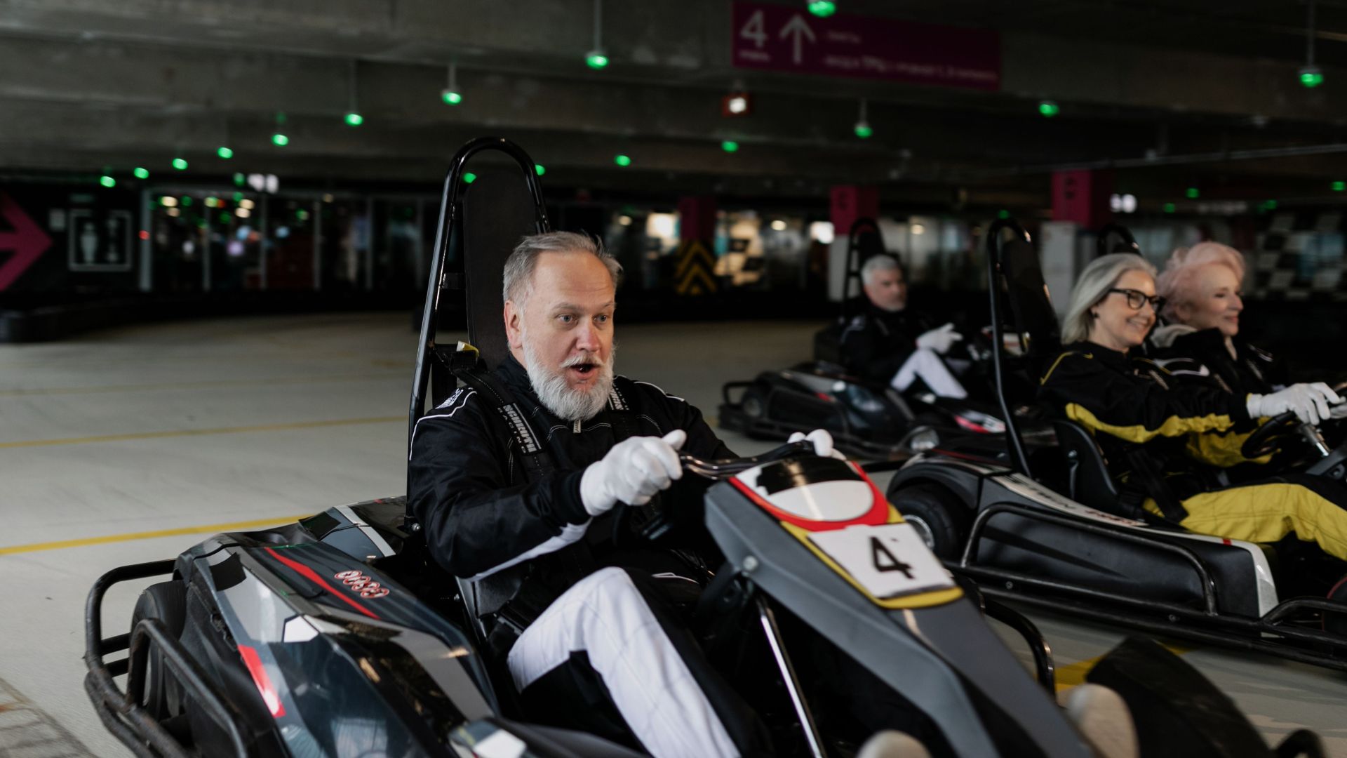 Seniors indulging in indoor go-karting, fostering camaraderie and recreation.