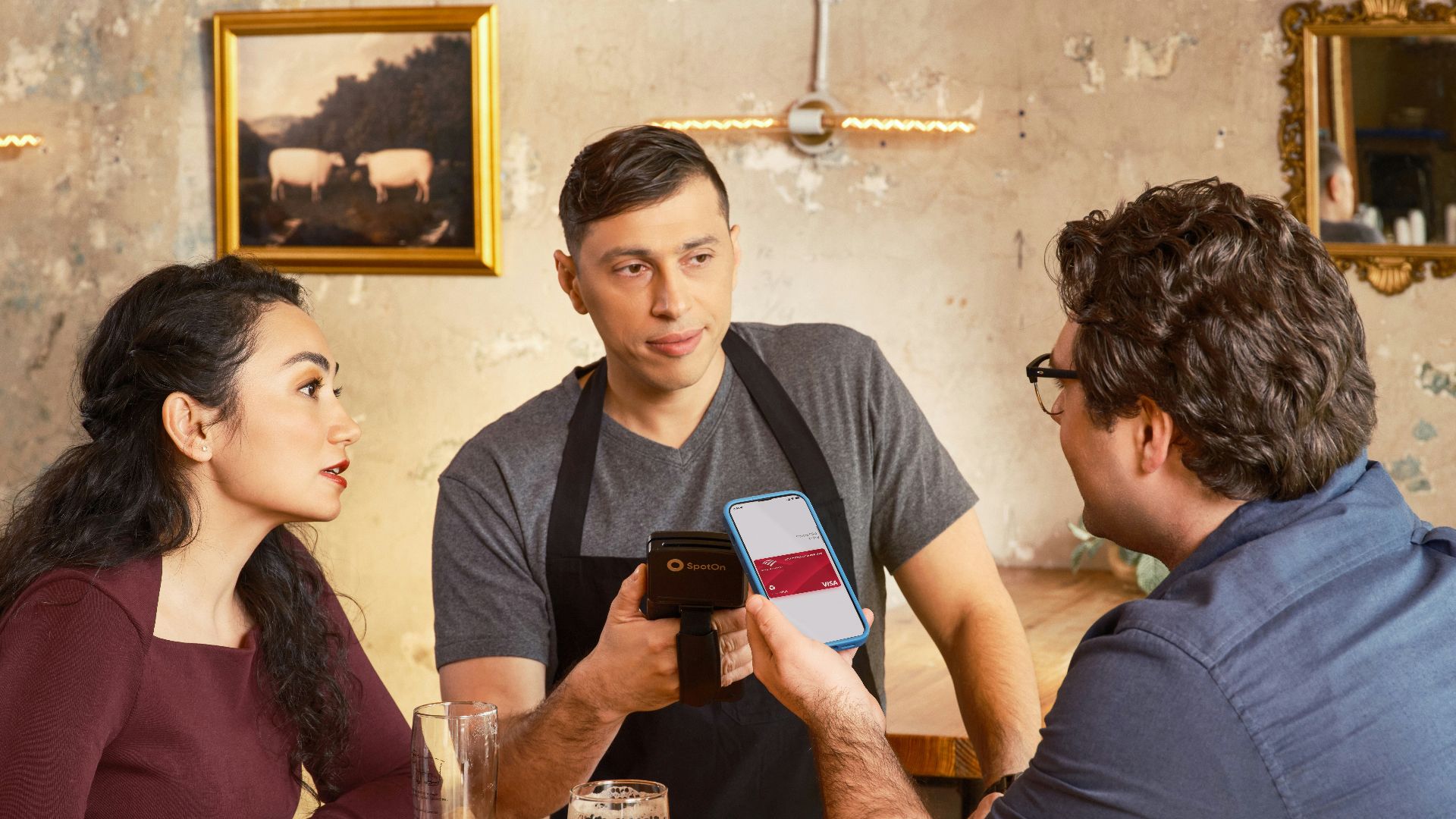 Customer pays with phone at a bar counter.