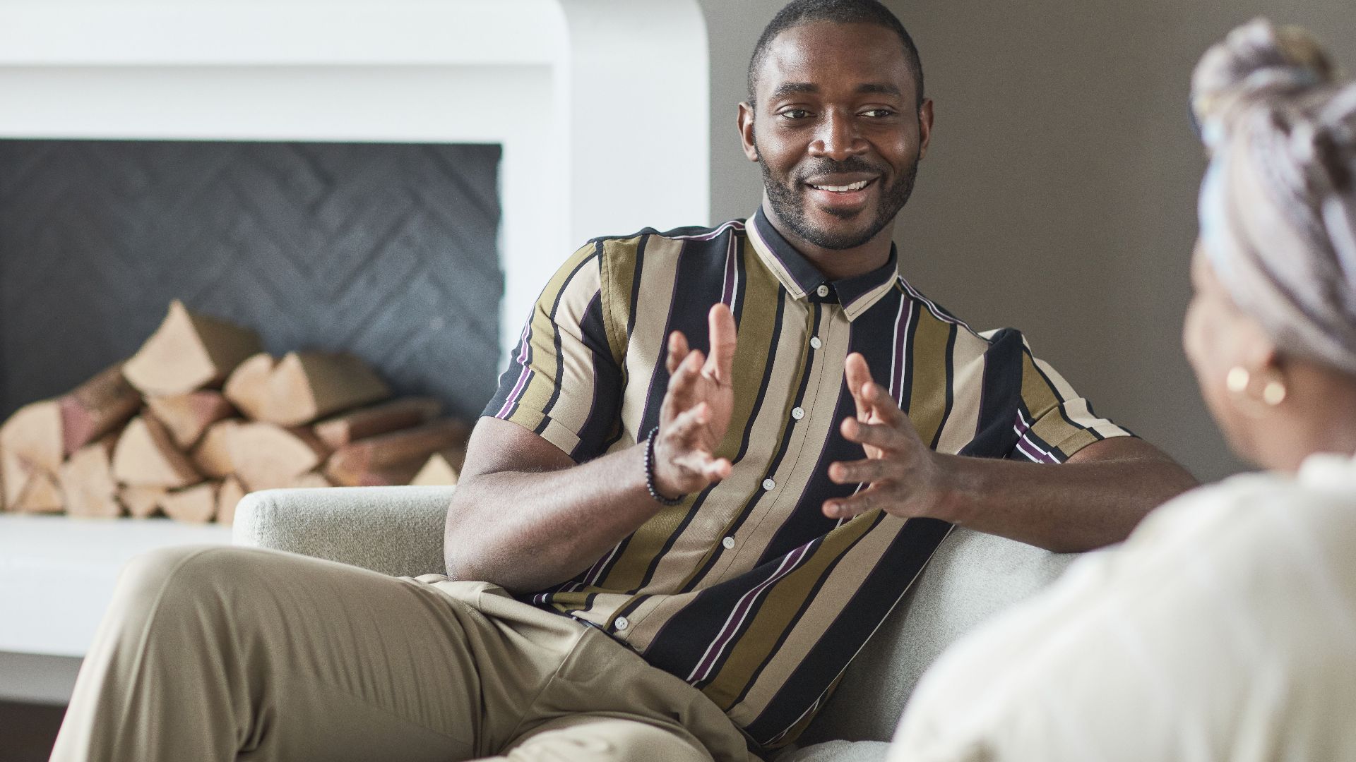 Two adults enjoying a friendly conversation in a cozy modern living room setting.
