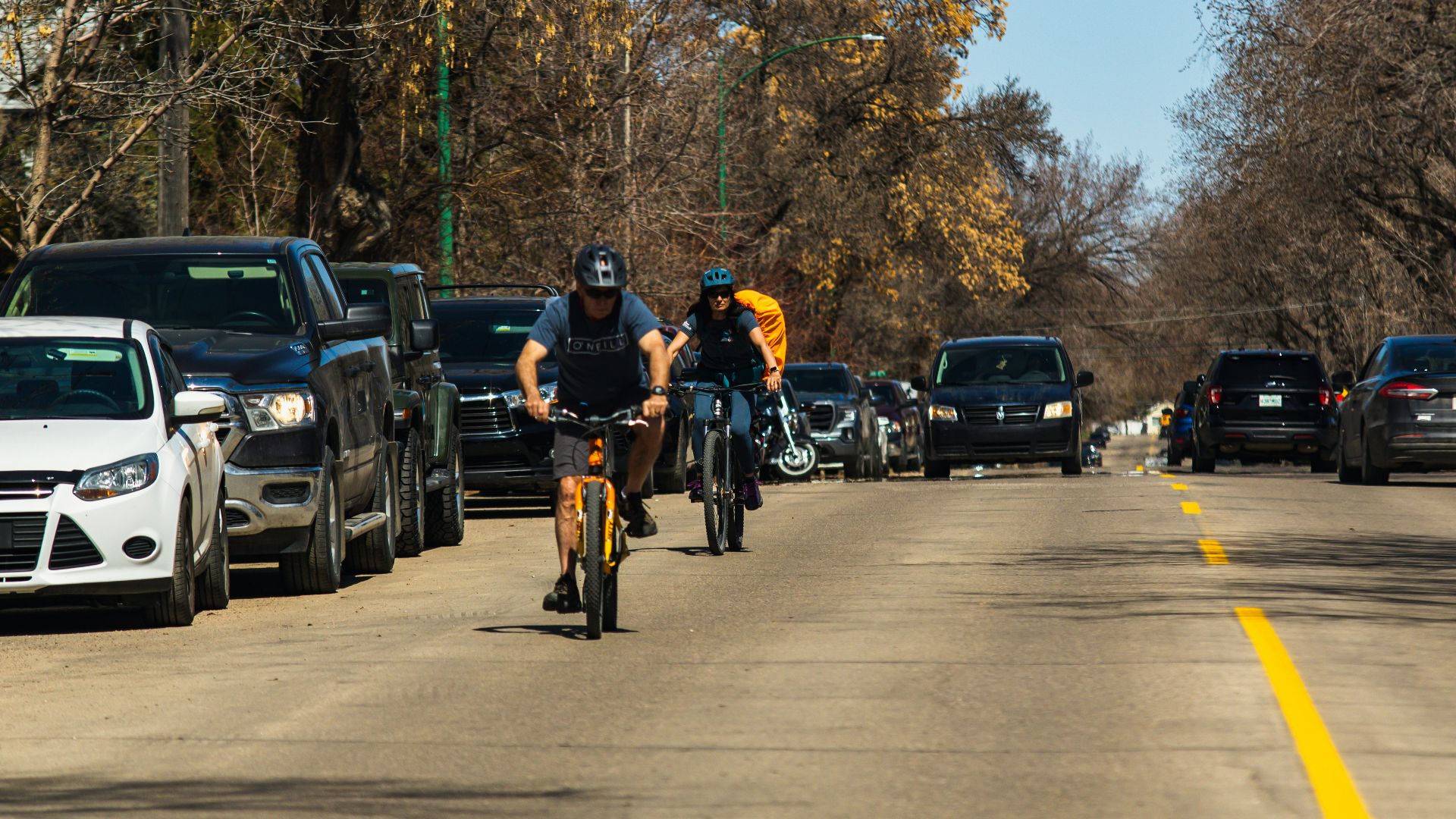 a couple of people riding bikes down a street