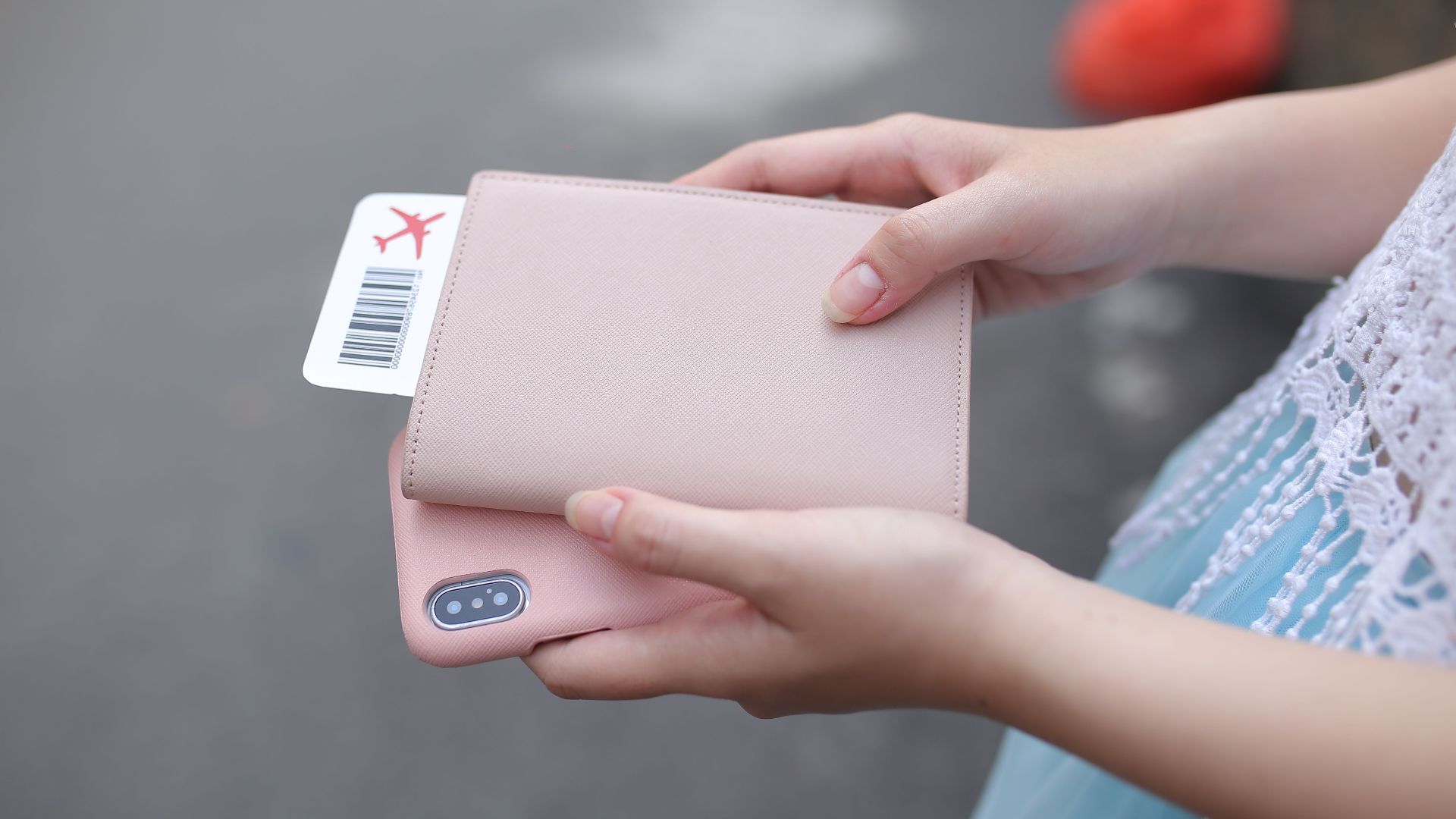 A woman holding a passport with a boarding pass and a smartphone, ready for travel.