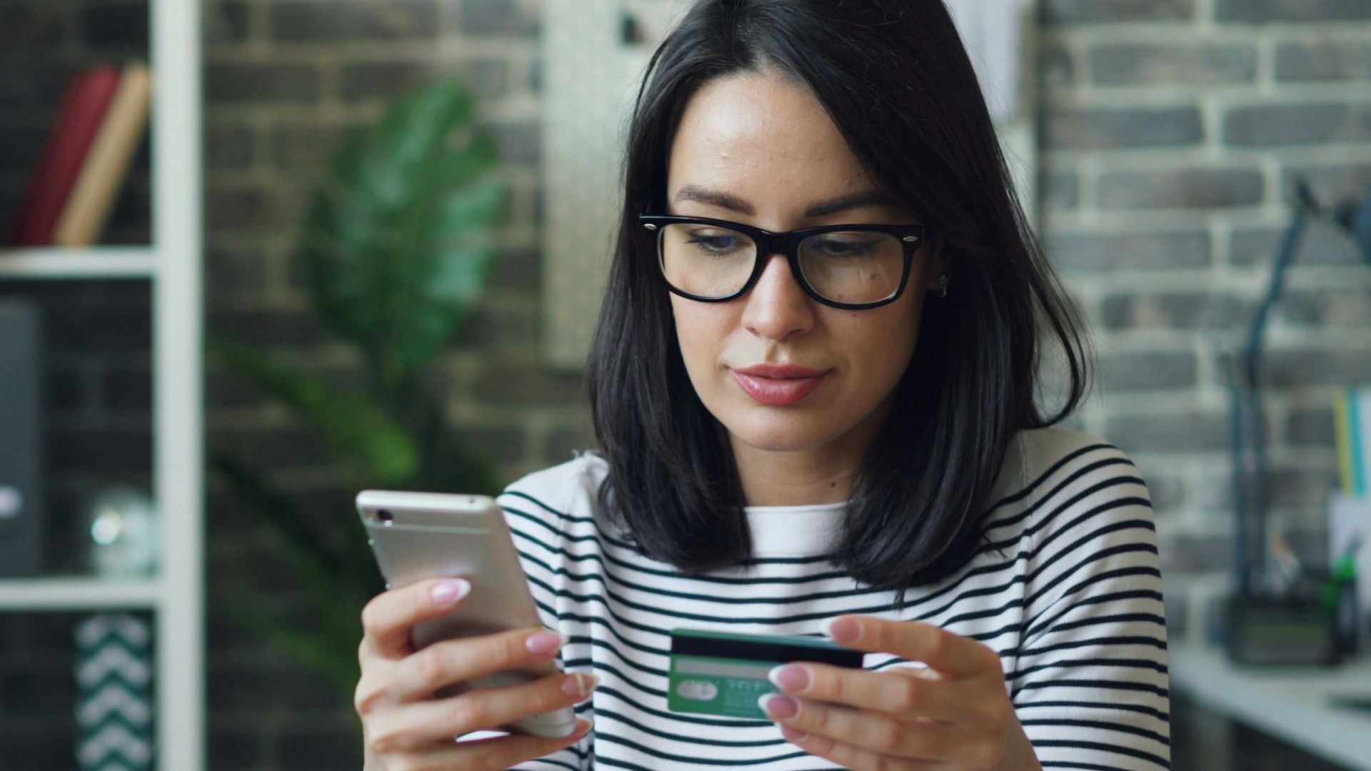a woman sitting at a table looking at her cell phone