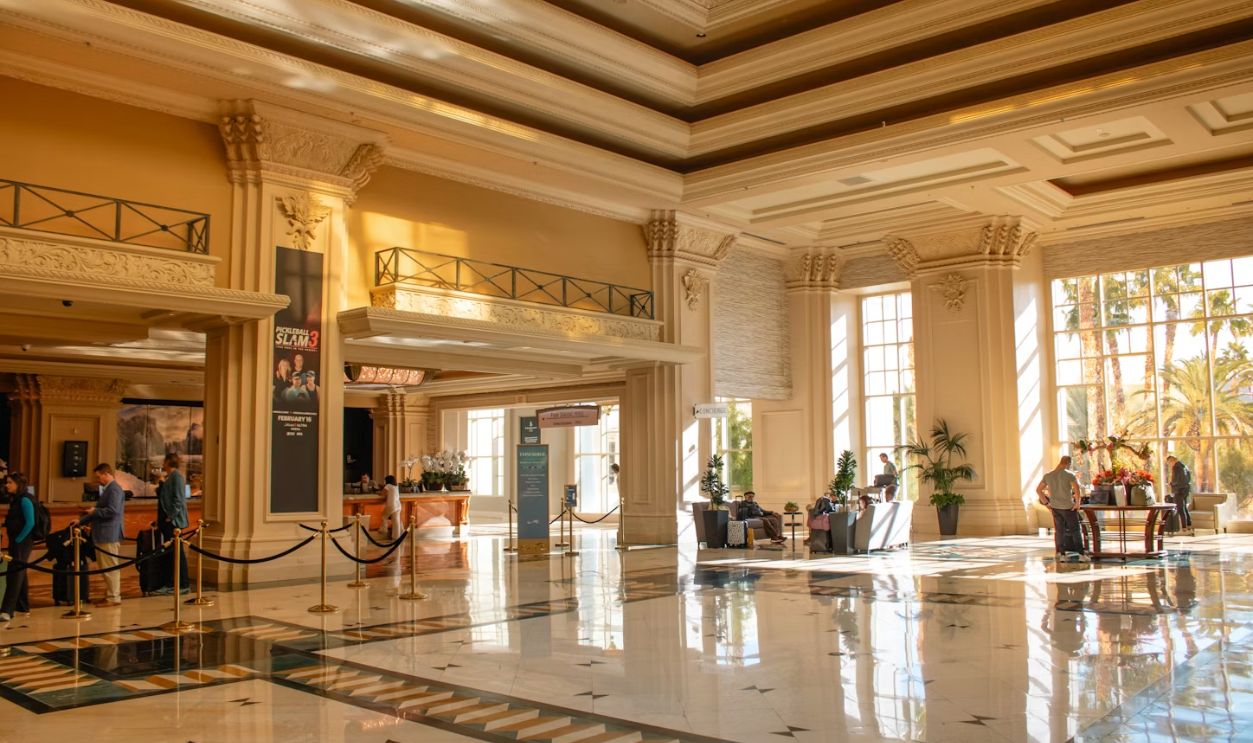 A grand hotel lobby filled with sunlight.