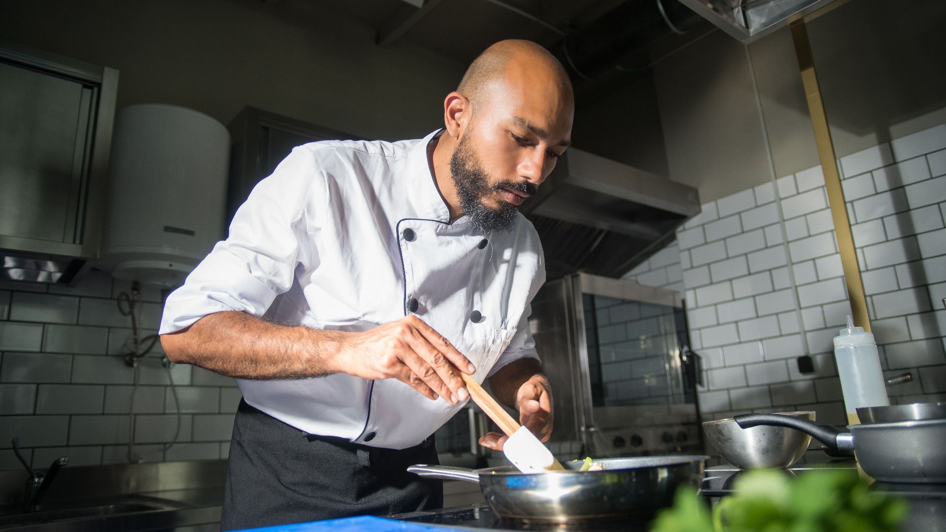 Chef preparing a dish in a modern kitchen, showcasing culinary skills.
