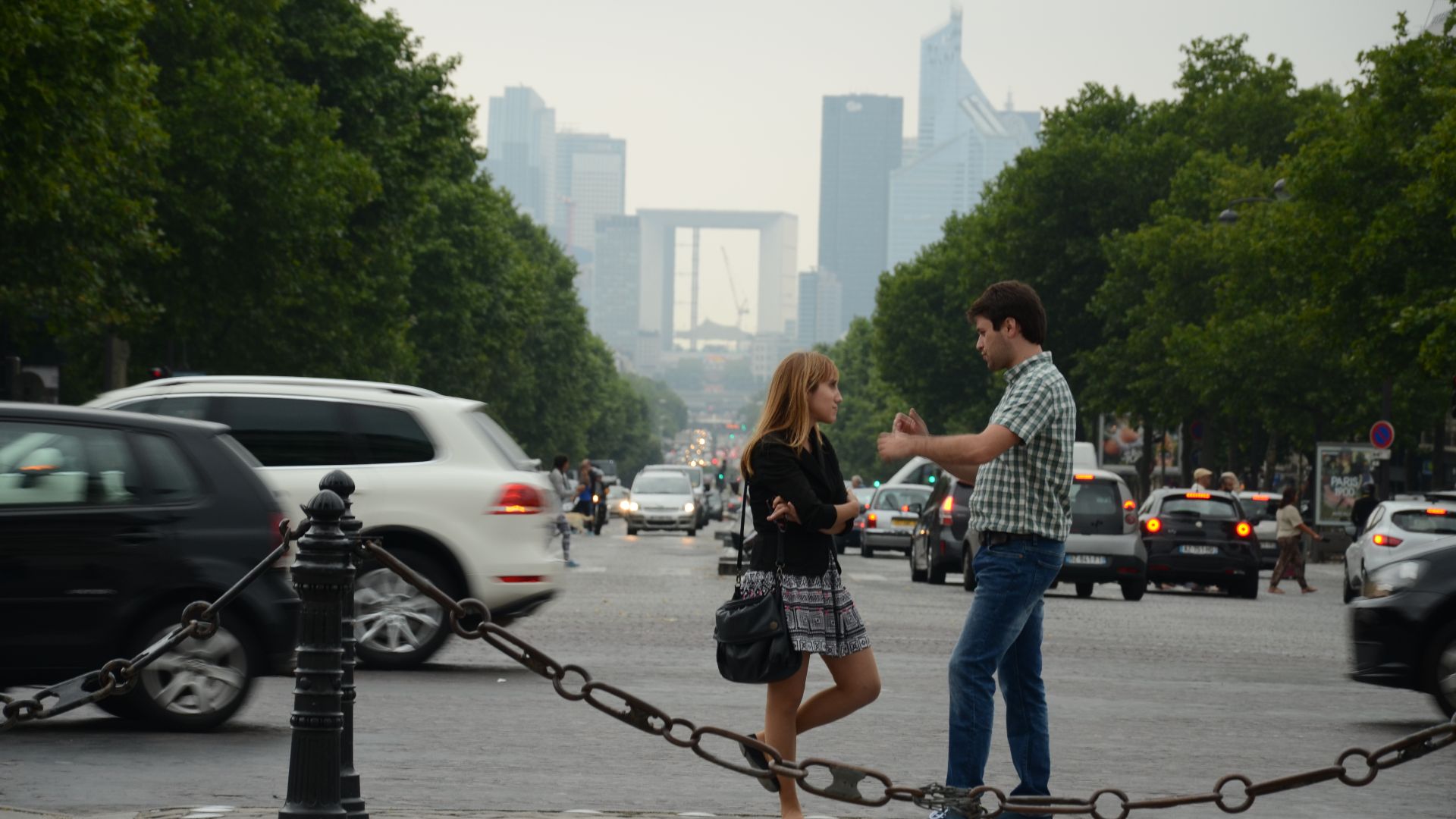 Twee converserende mensen met op de achtergrond de Grande Arche.