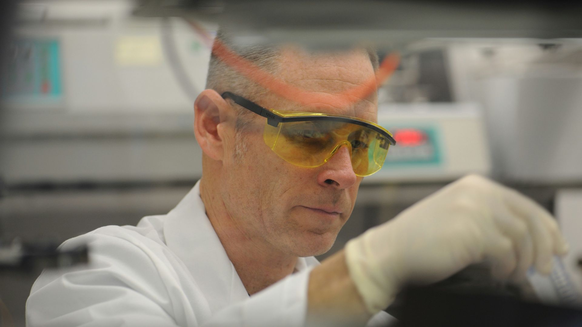 a man in a lab wearing safety goggles