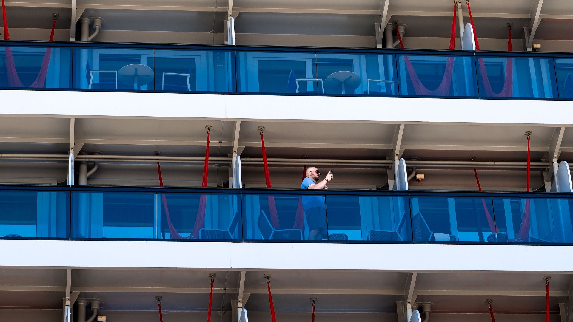 Aerial view of a modern cruise ship with blue balconies docked in İstanbul, Türkiye.