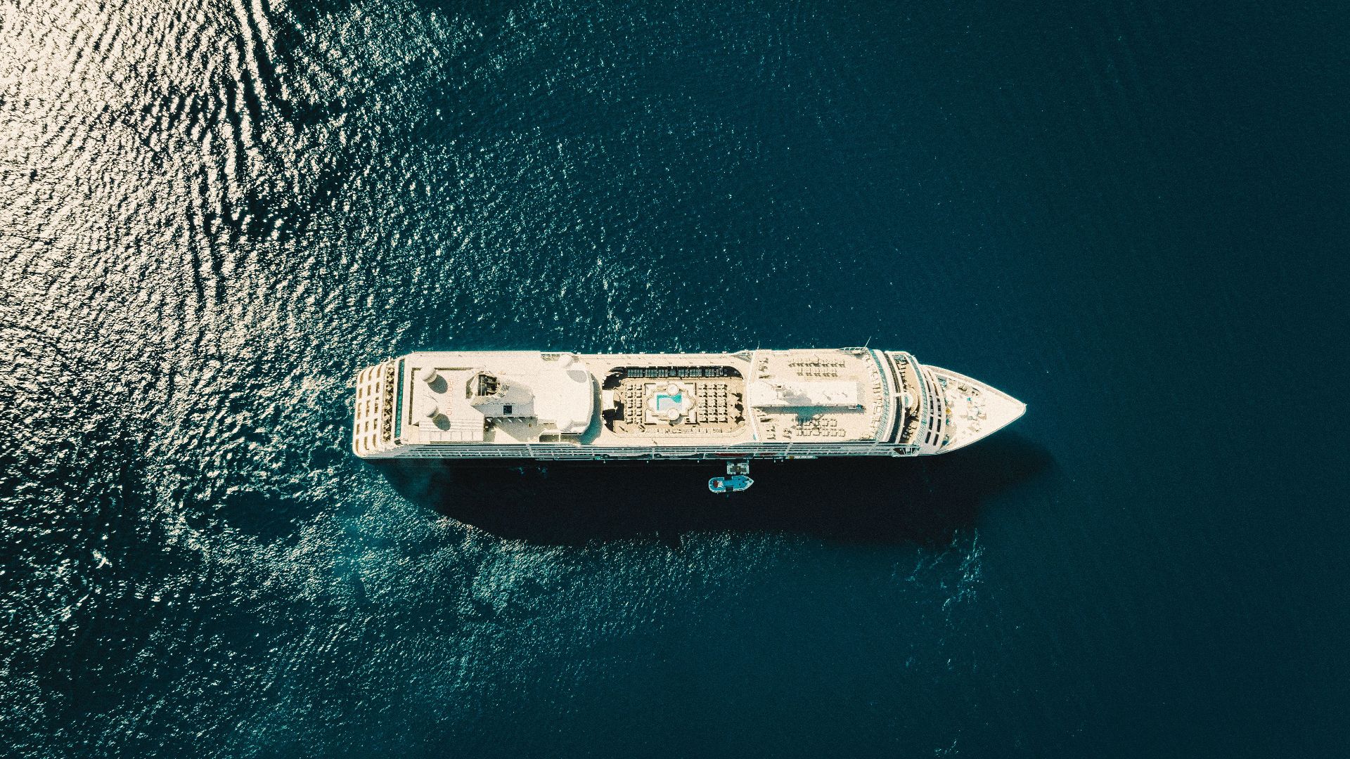 A stunning aerial view of a cruise ship sailing through the deep blue ocean.
