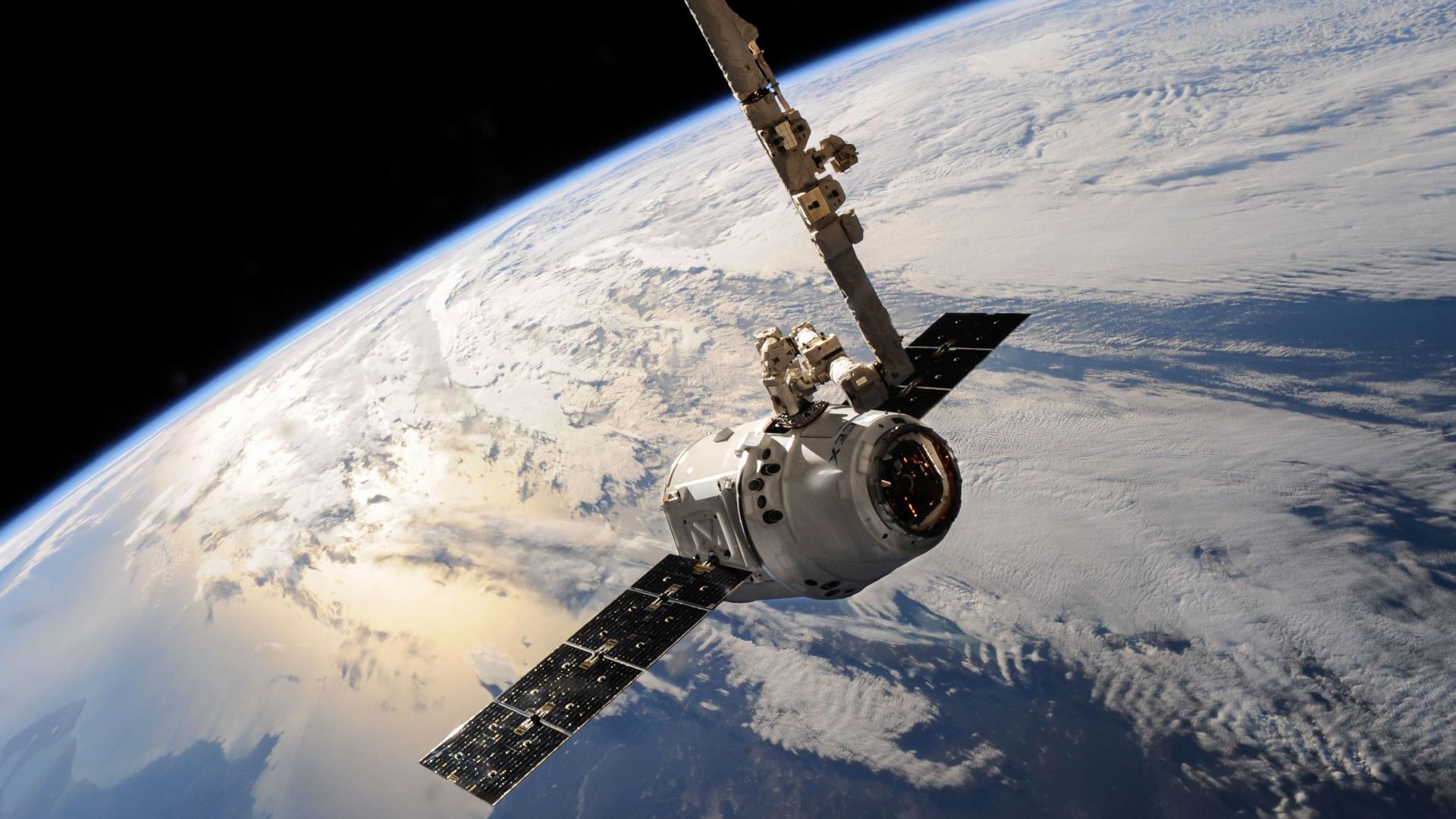 A satellite glides over Earth showcasing dramatic cloud formations and the vast expanse of space.