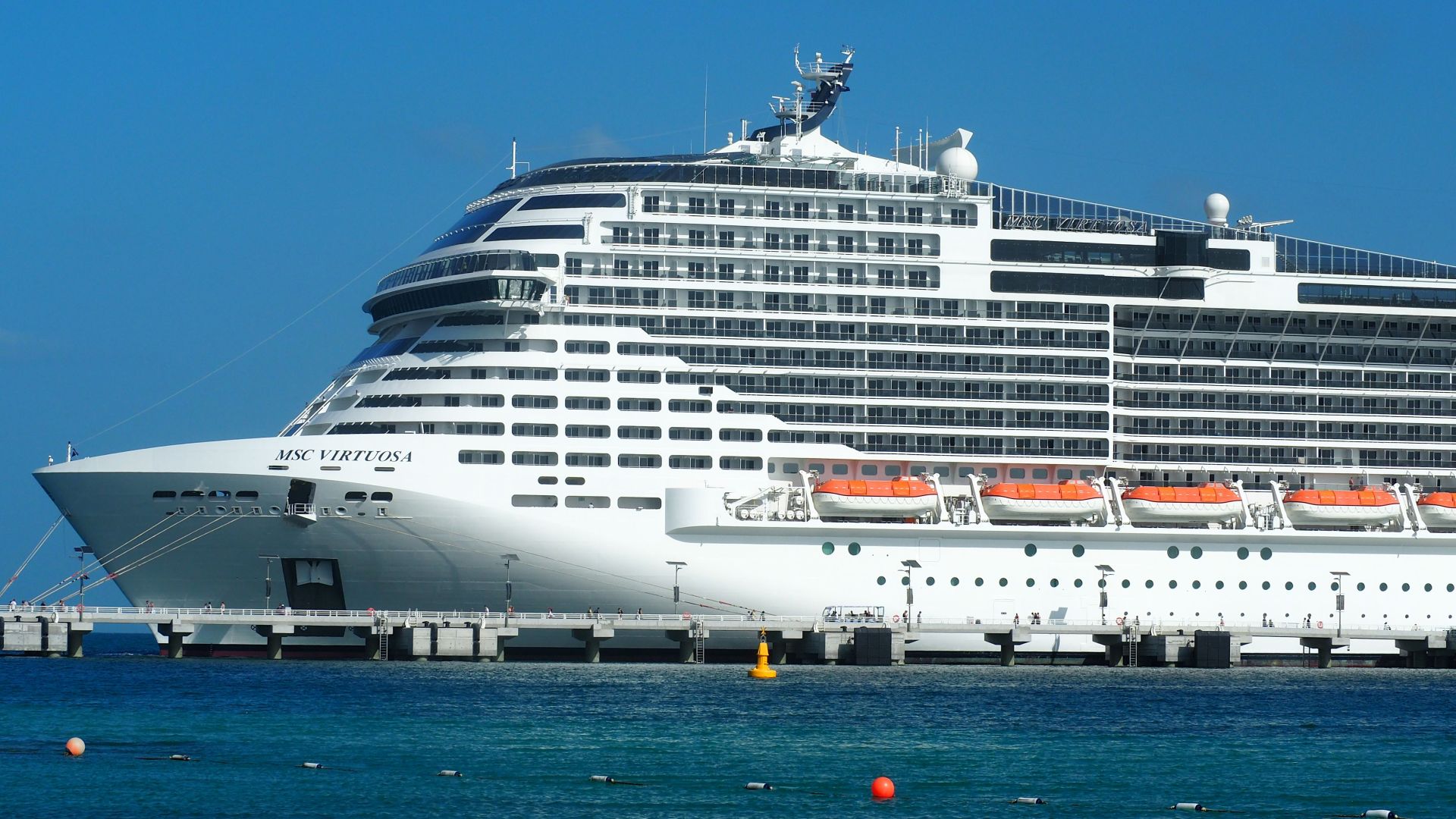 A breathtaking view of the MSC Virtuosa cruise ship docked in a sunny harbor.