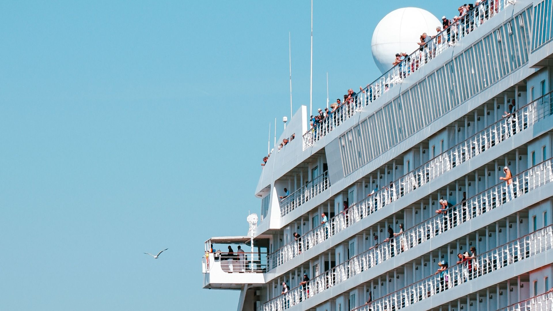 Large cruise ship sailing on the Bosporus Strait in Istanbul under a clear blue sky.