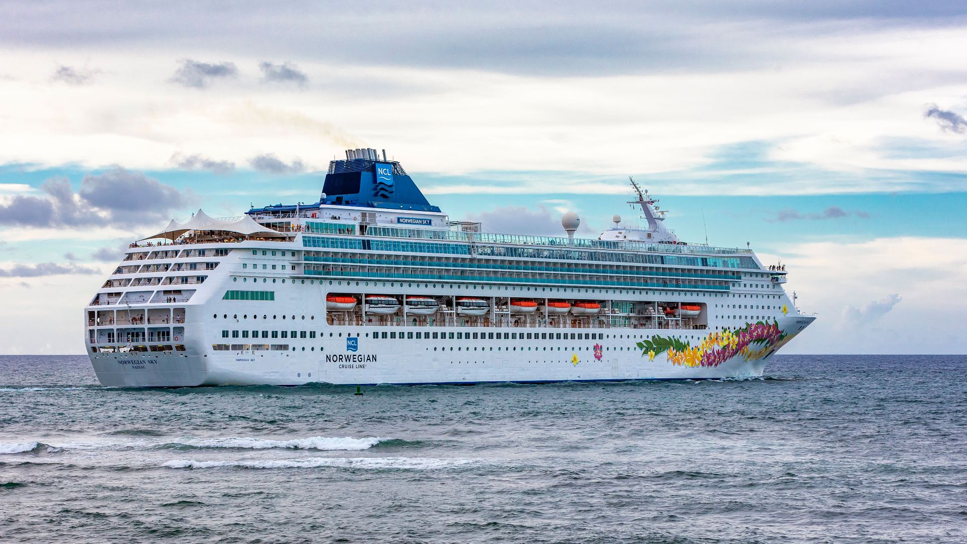 A majestic cruise ship sails near Puerto Plata, Dominican Republic, under a vibrant sky.