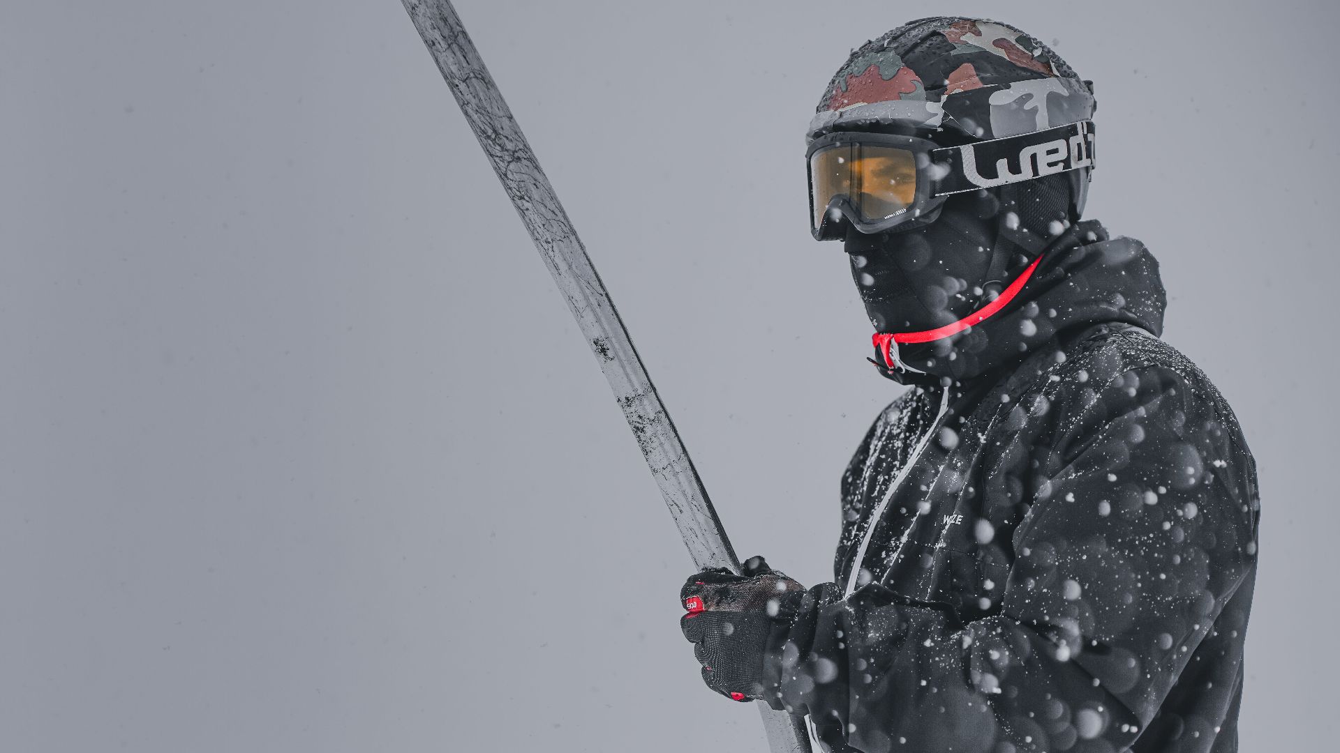 A skier in black attire navigating the snowy slopes of Gulmarg during heavy snowfall.