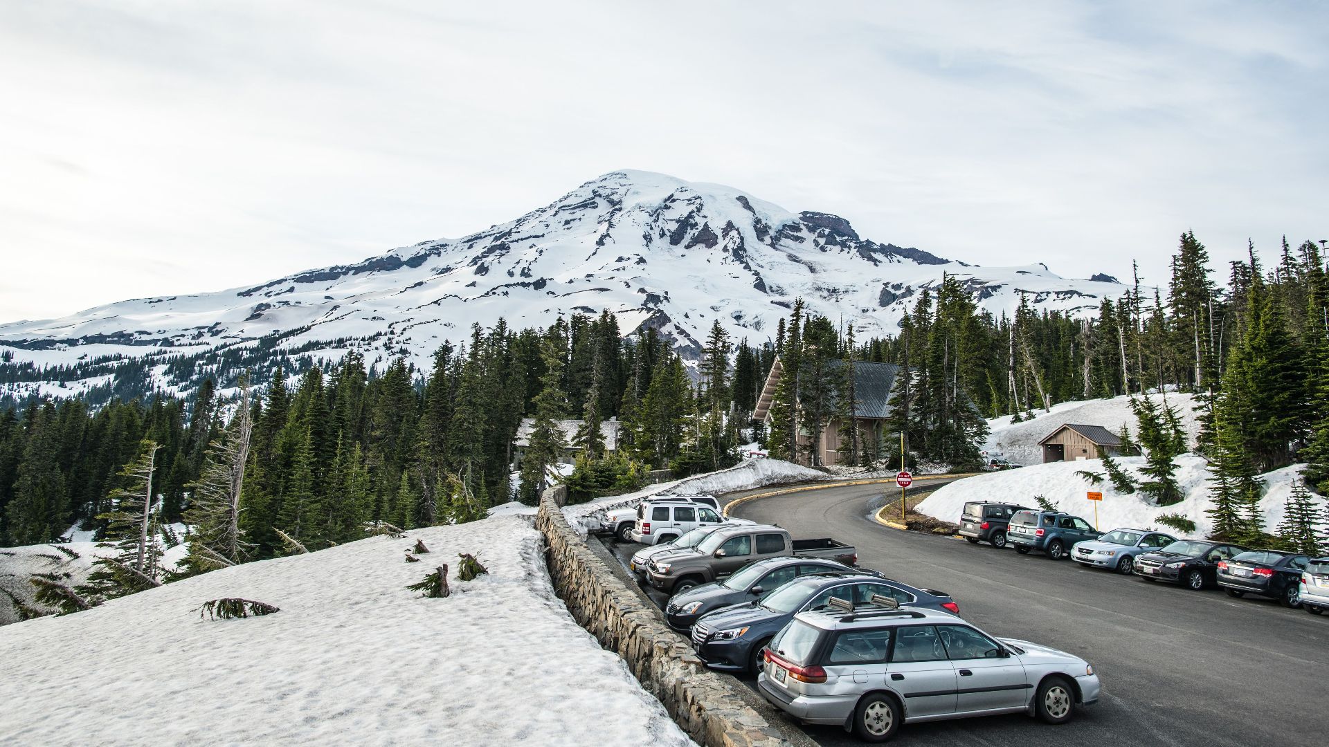 Scenic view of a snowy mountain landscape with parked cars.