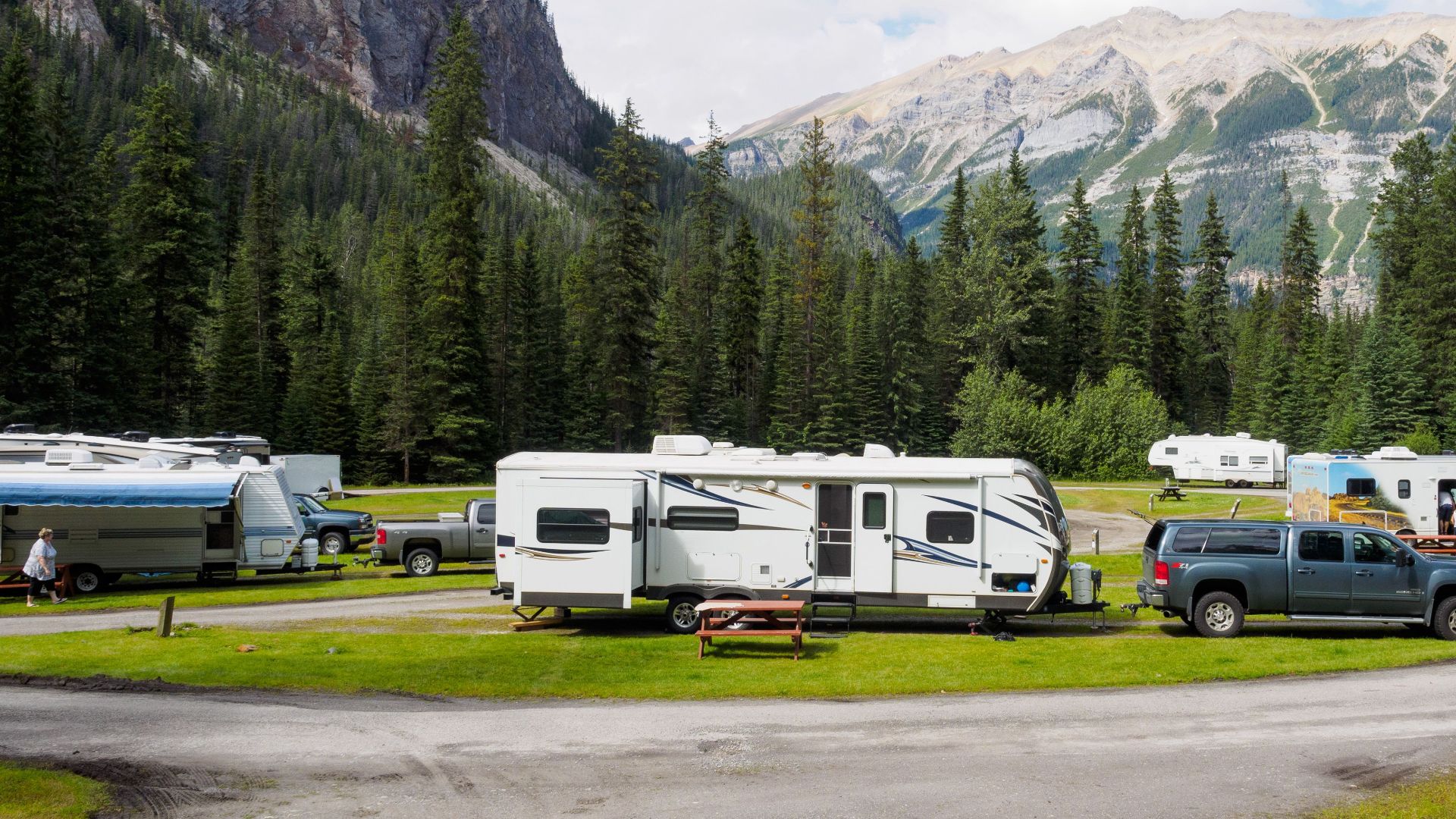A beautiful campsite featuring RVs amidst lush forests and towering mountains for a peaceful getaway.