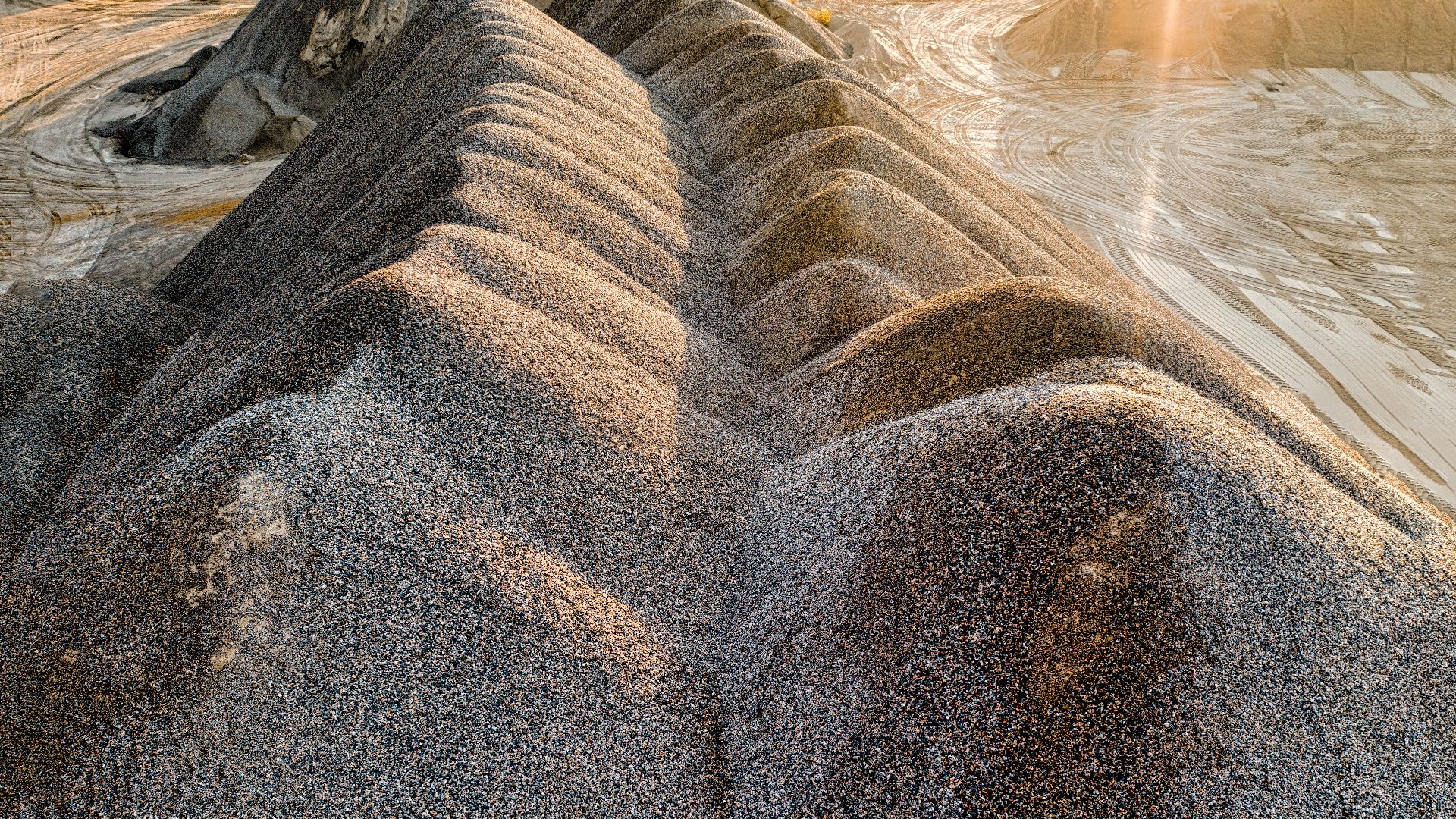 Drone shot of sunlit gravel formations in Rochester, MN quarry, showcasing natural textures.