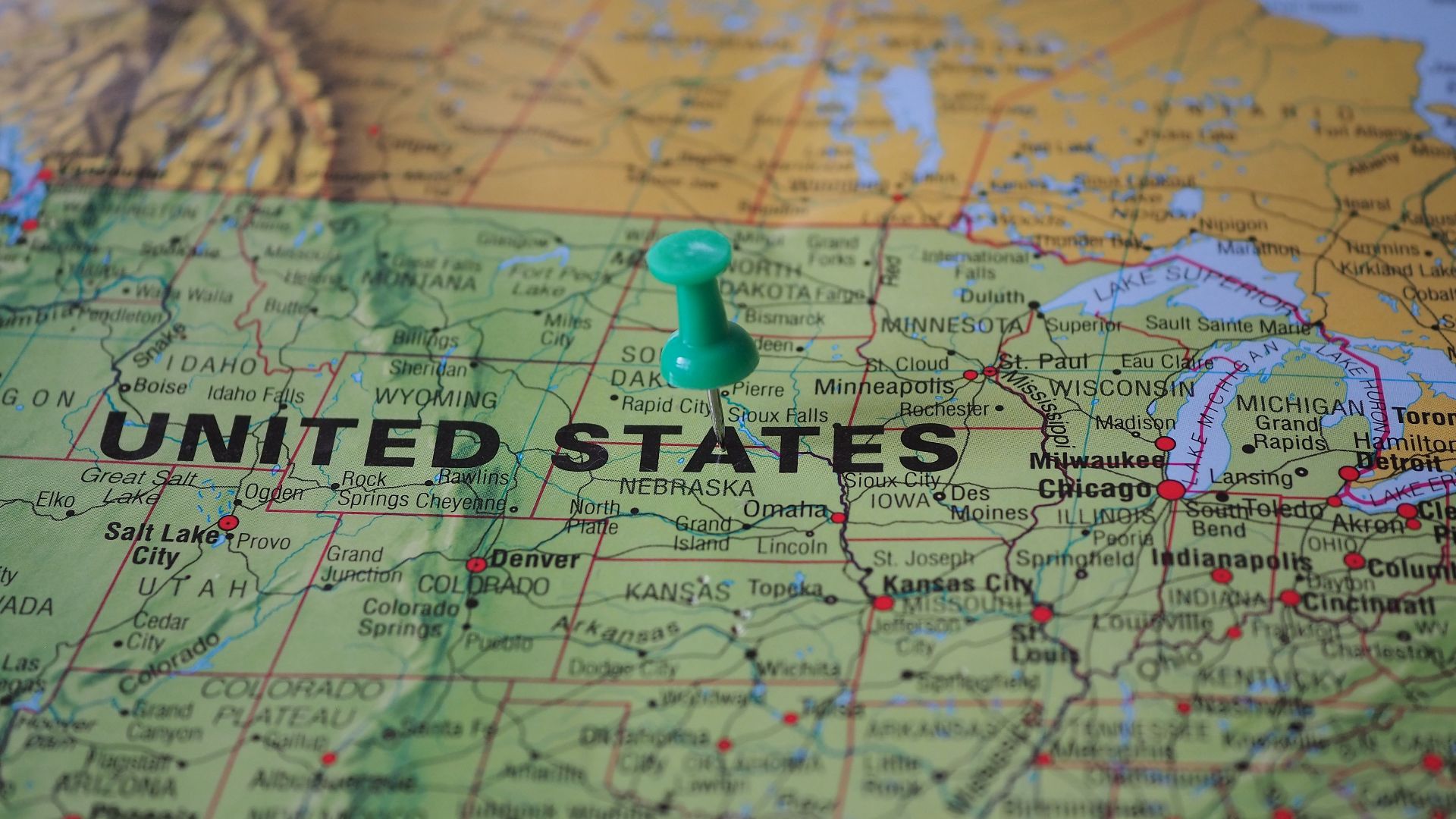 High-angle view of a map featuring the United States with a green pin indicating a specific location.