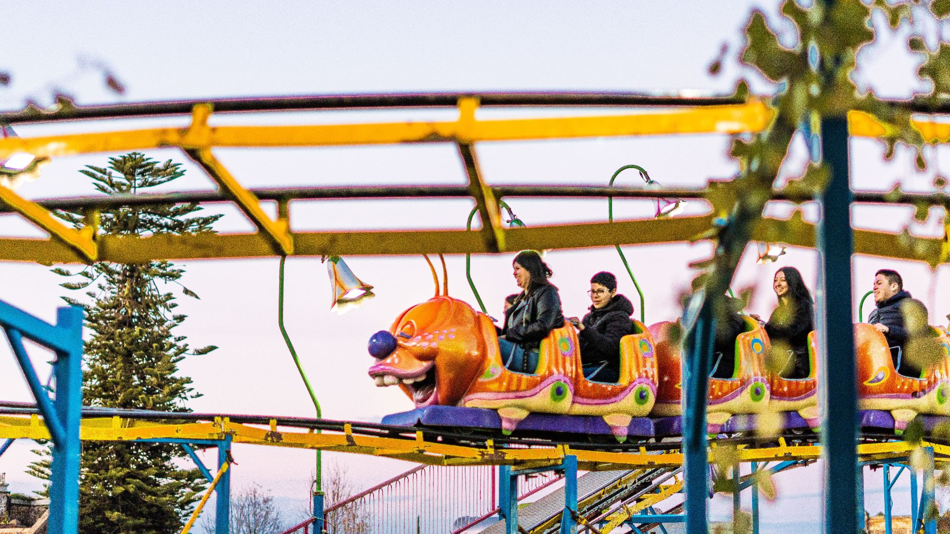 Experience the thrill of a colorful roller coaster ride at a Tlaxcala amusement park, featuring joyful riders.