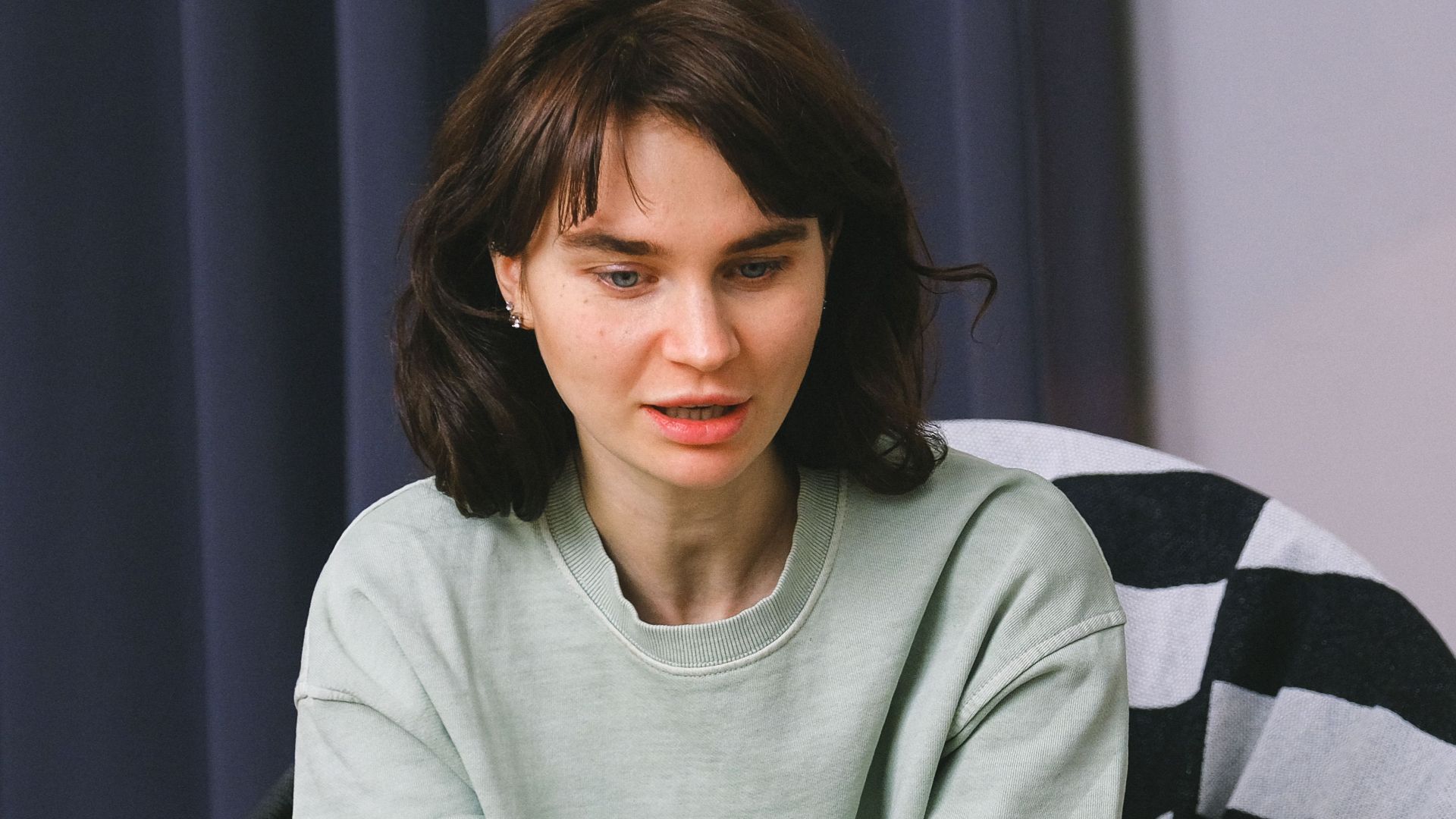 Calm female sitting on armchair and giving interview to concentrated woman in light room