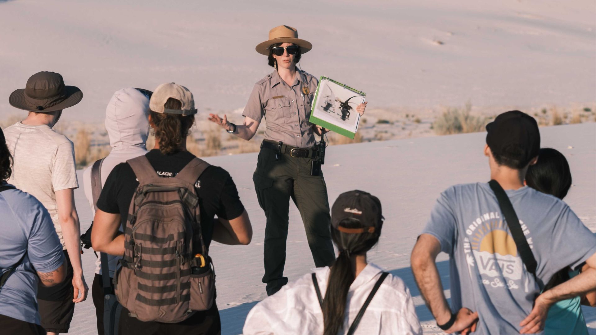 Group of tourists with a guide exploring White Sands National Park during daytime.