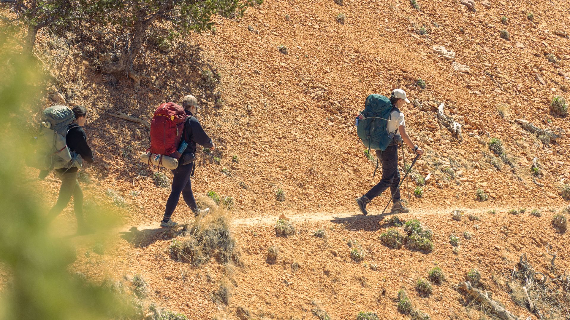 Three hikers traverse the rocky trails of Bryce Canyon National Park, showcasing adventure in Utah's natural beauty.