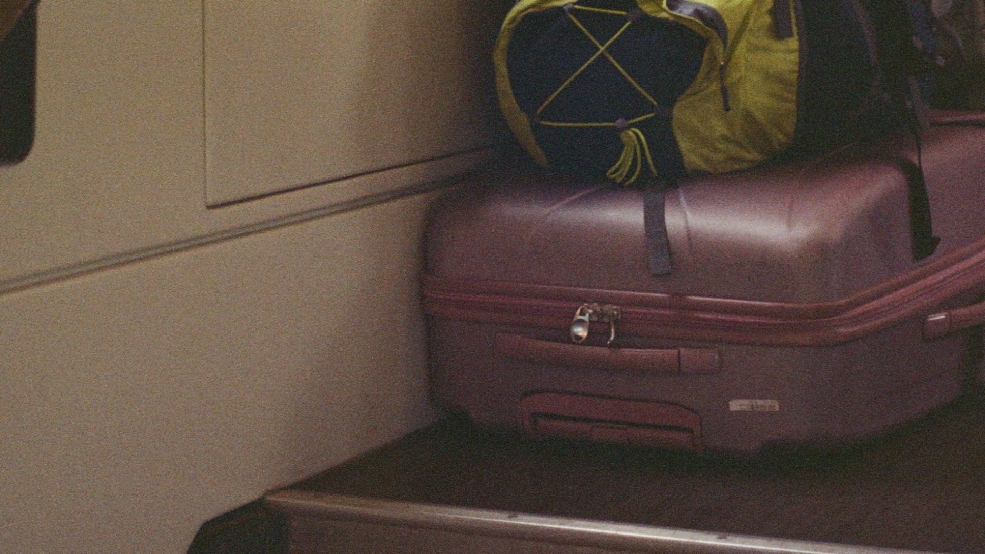 Bags piled on stairway inside a train, perfect for travel-themed content.