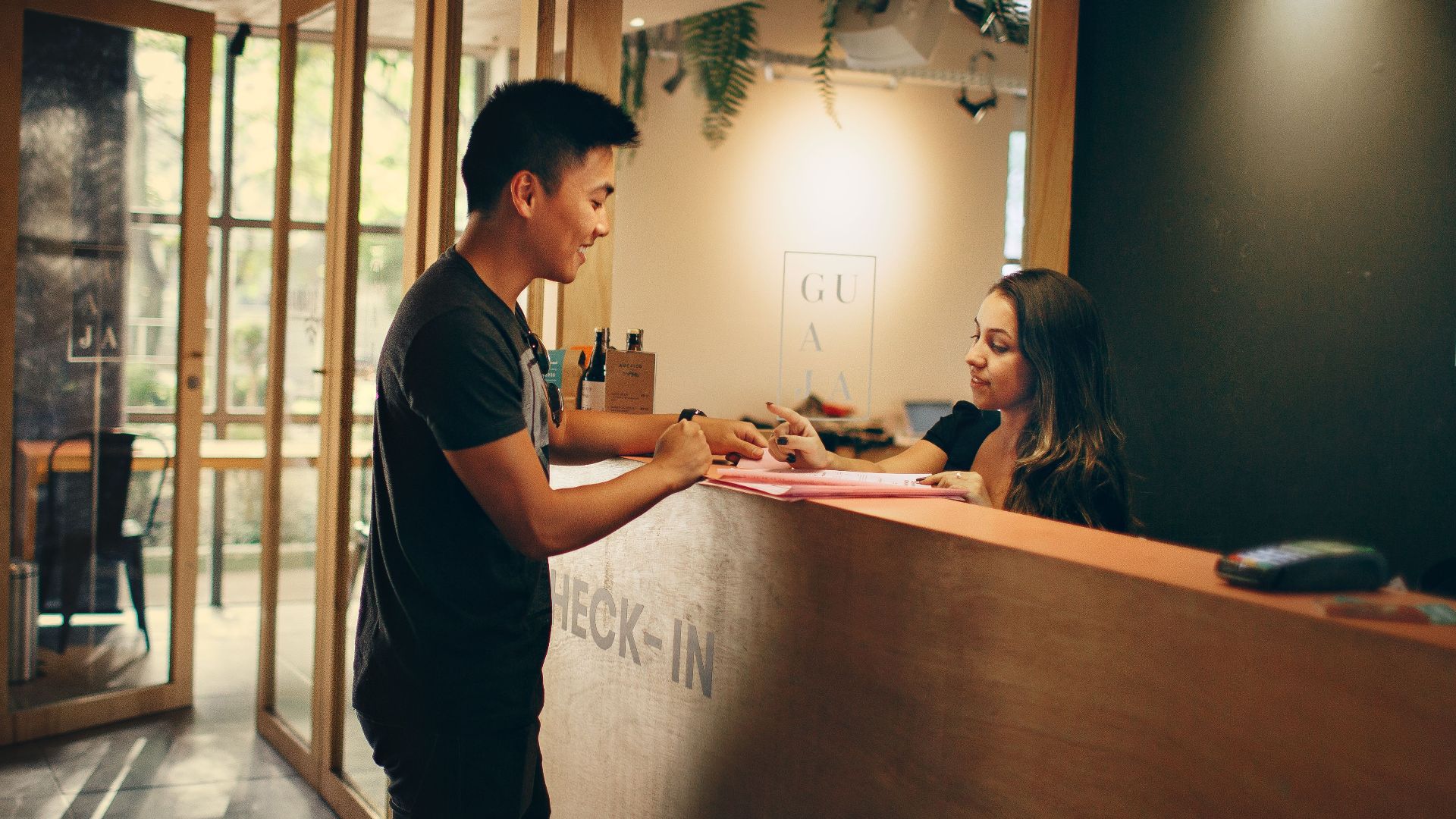 A customer checks in at a hotel reception desk in Belo Horizonte, Brazil.