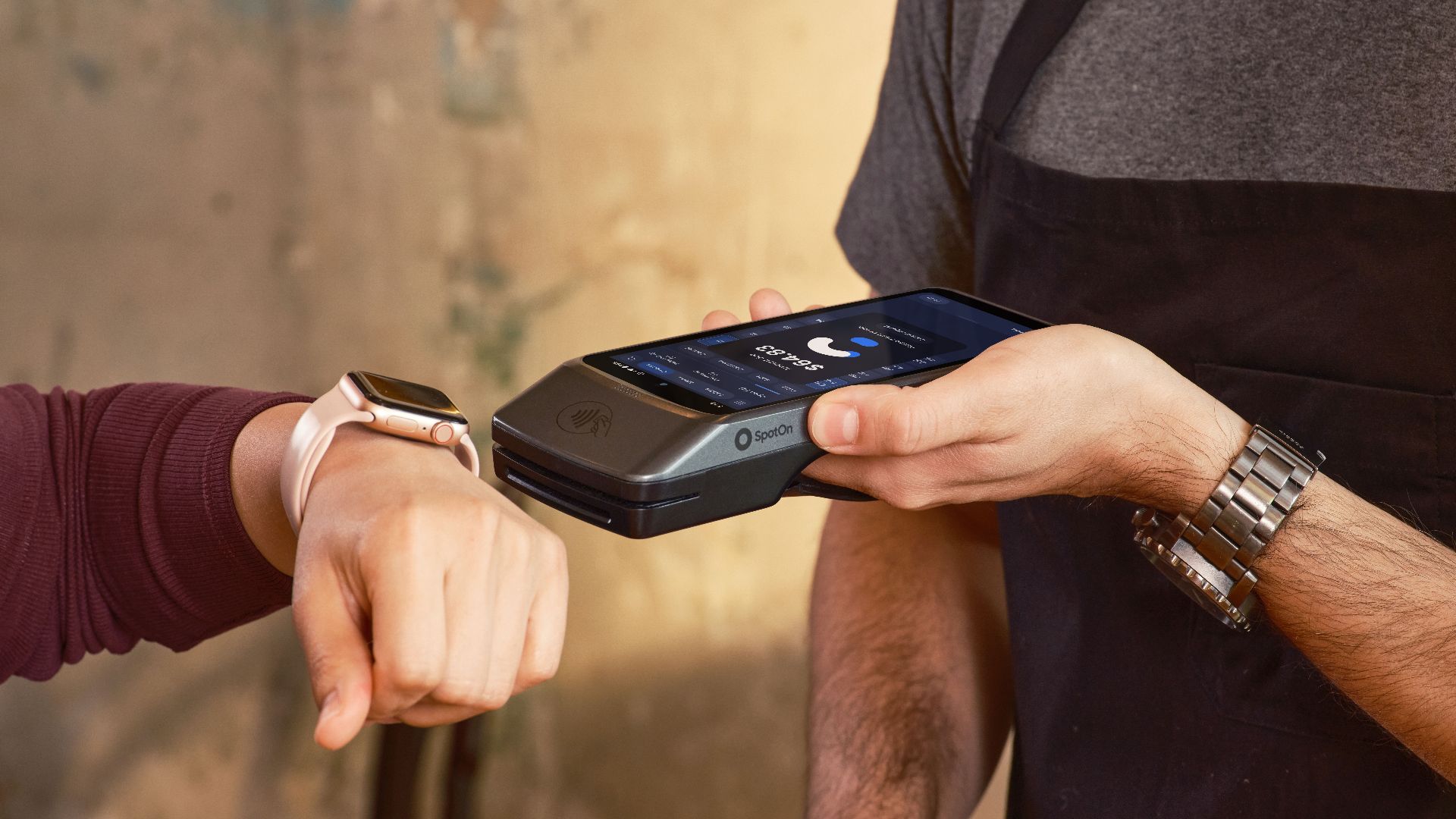 Smartwatch user making a contactless payment at a café using a POS device.