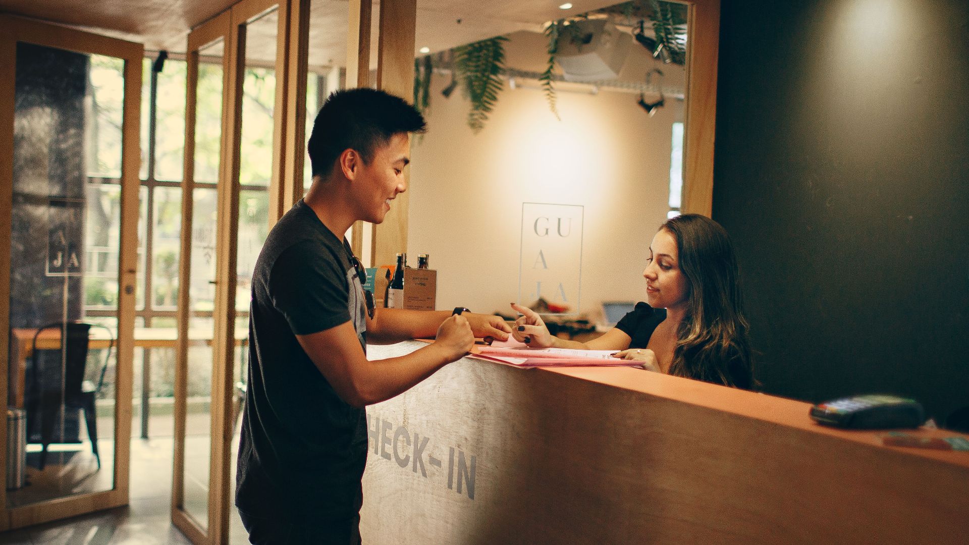 A customer checks in at a hotel reception desk in Belo Horizonte, Brazil.